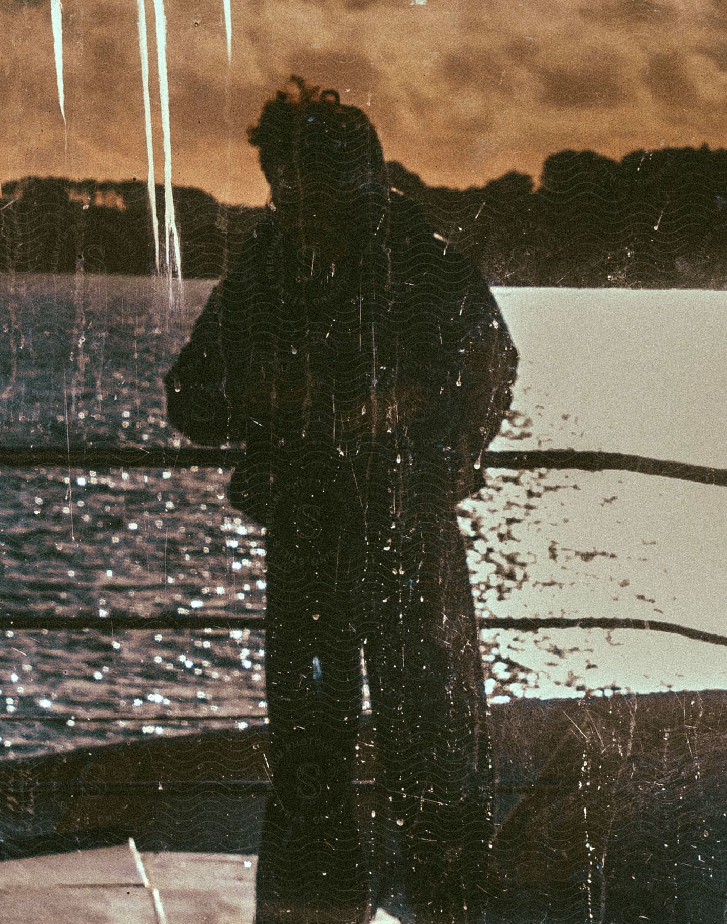 Silhouette of a person and the sea in the background.