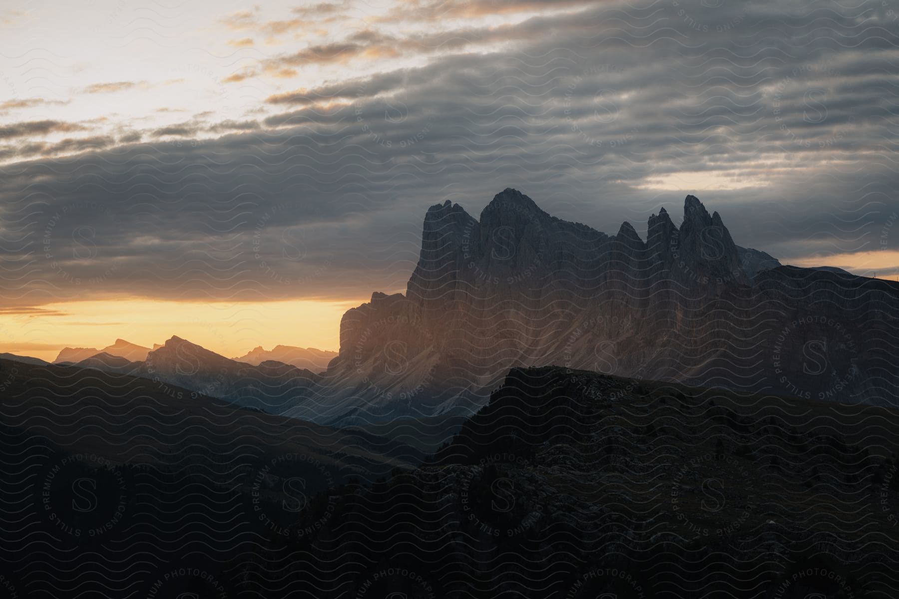 An aerial of a mountainous region as the sun rises over the horizon.