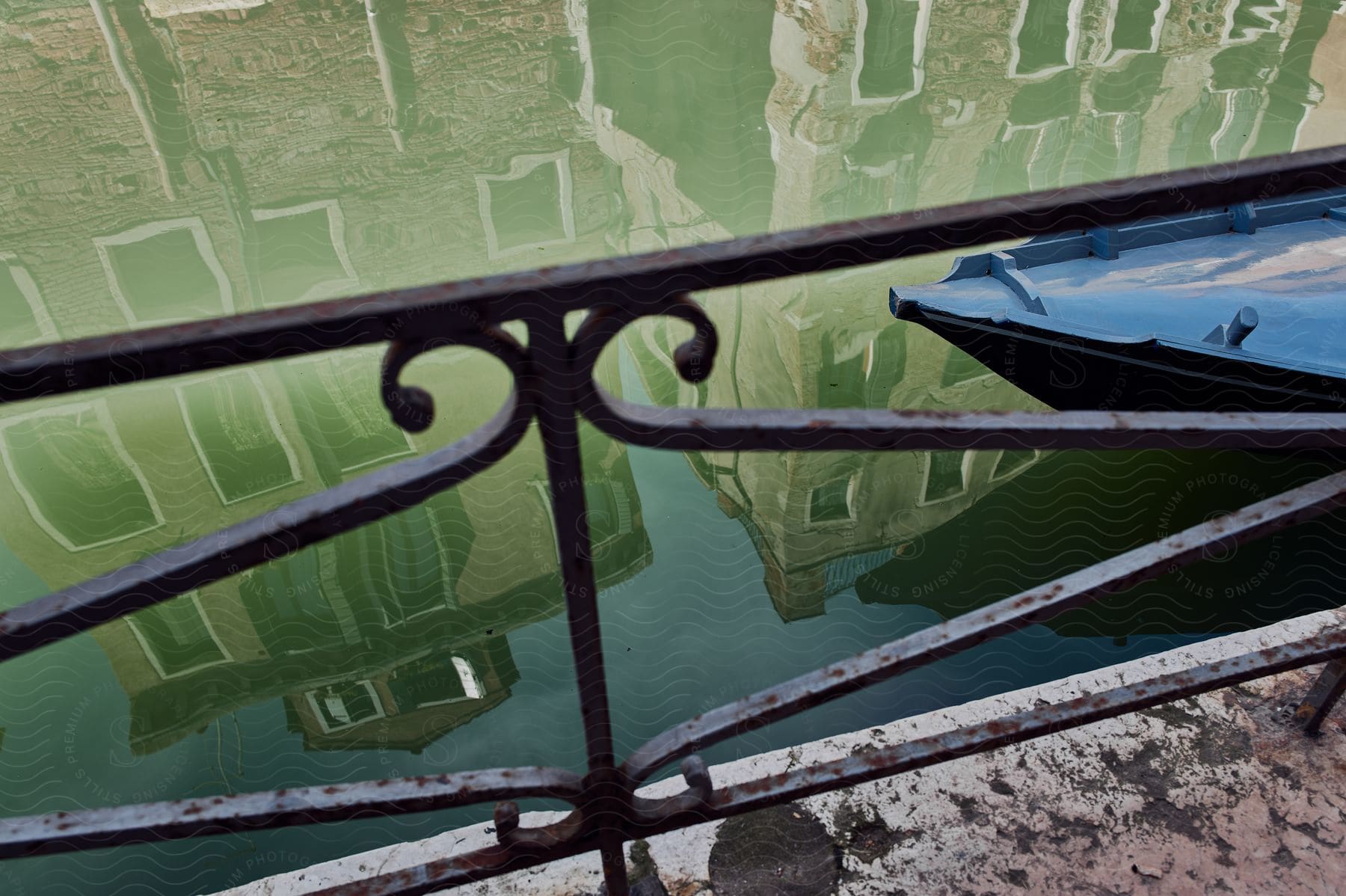 a boat passes by a balcony over a canal