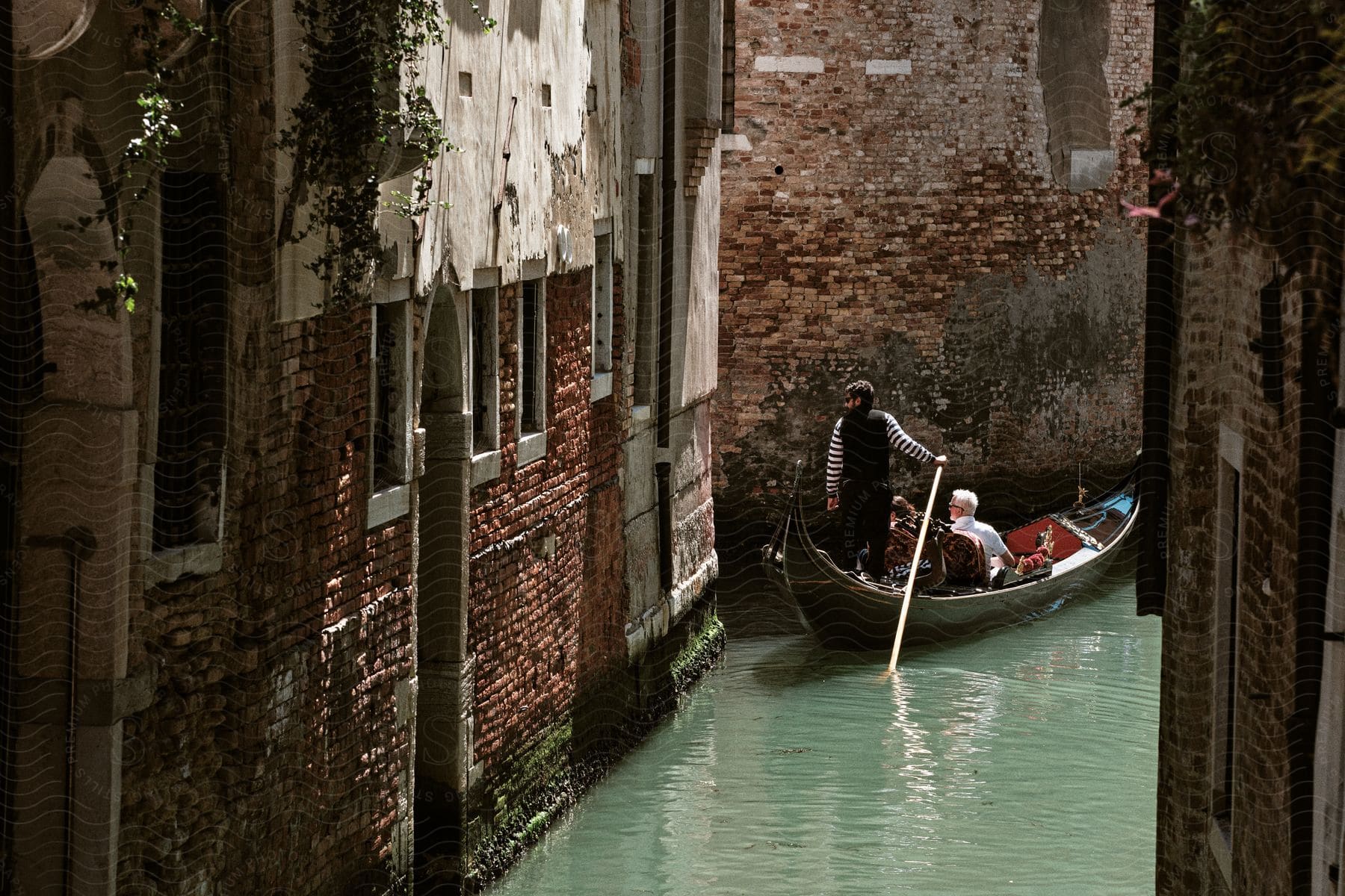 a gondola operator navigates people down a canal
