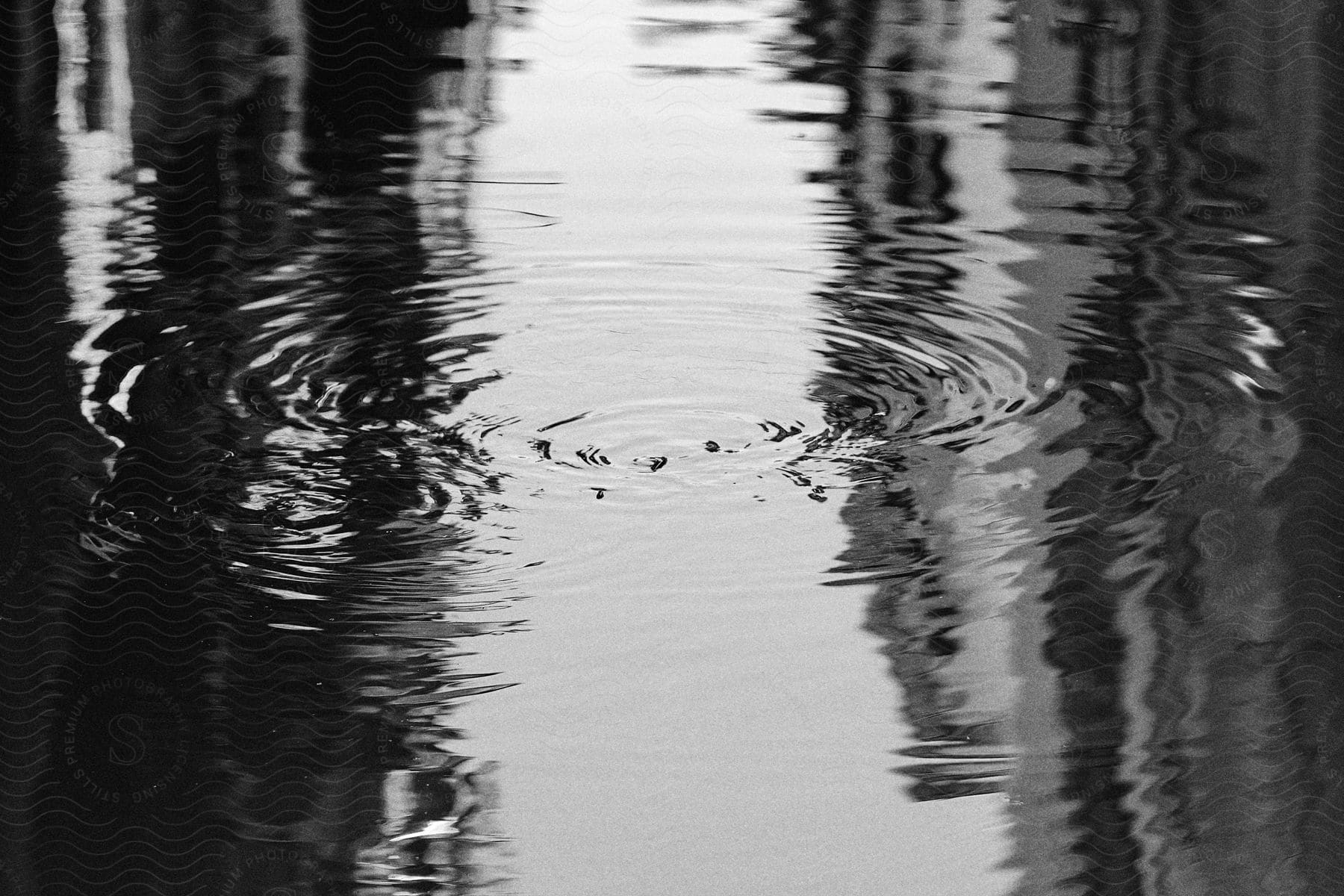 Circular ripples on a shallow body of water in a city.