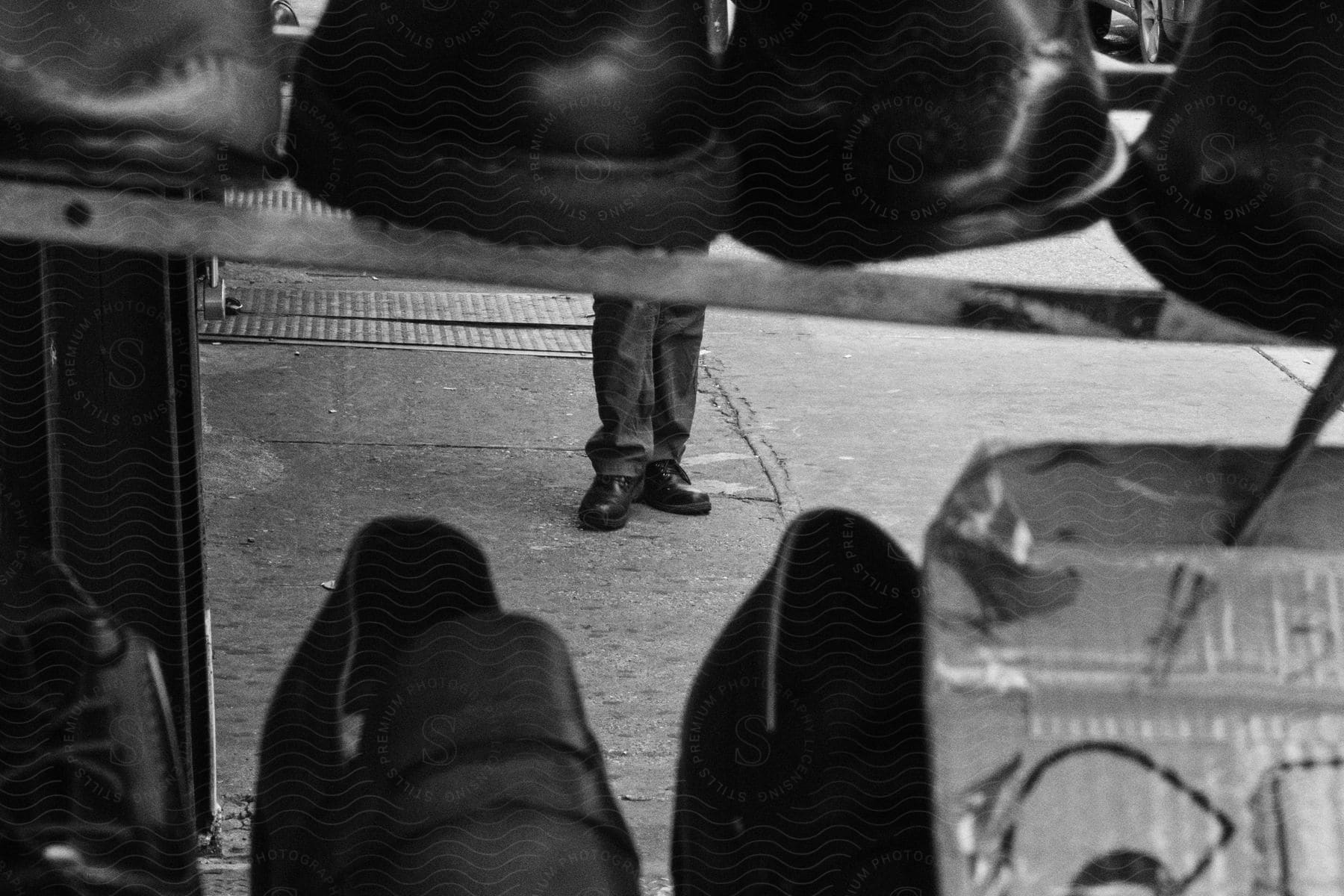 A man's is wearing dress shoes and pants in front of a shoe store display.