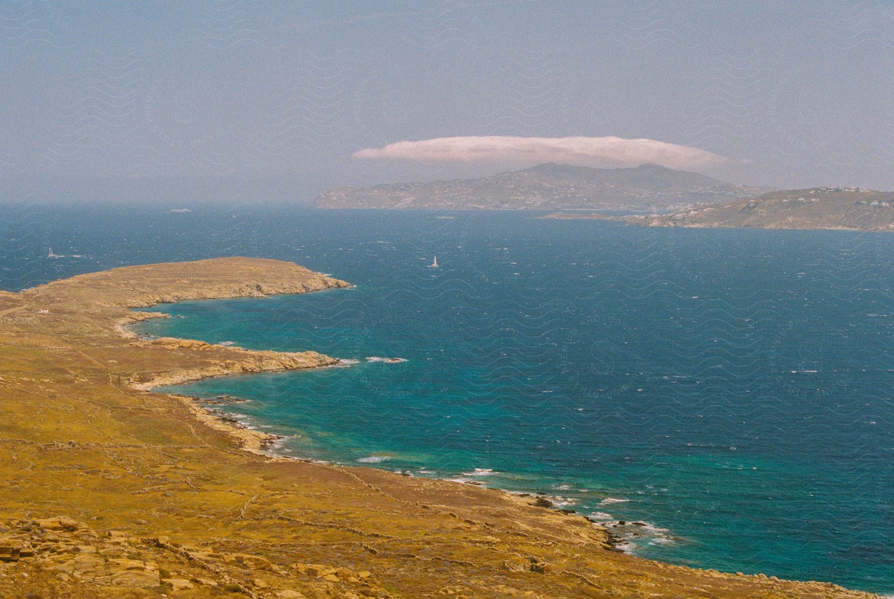 An island is situated between the bright blue water and another island.
