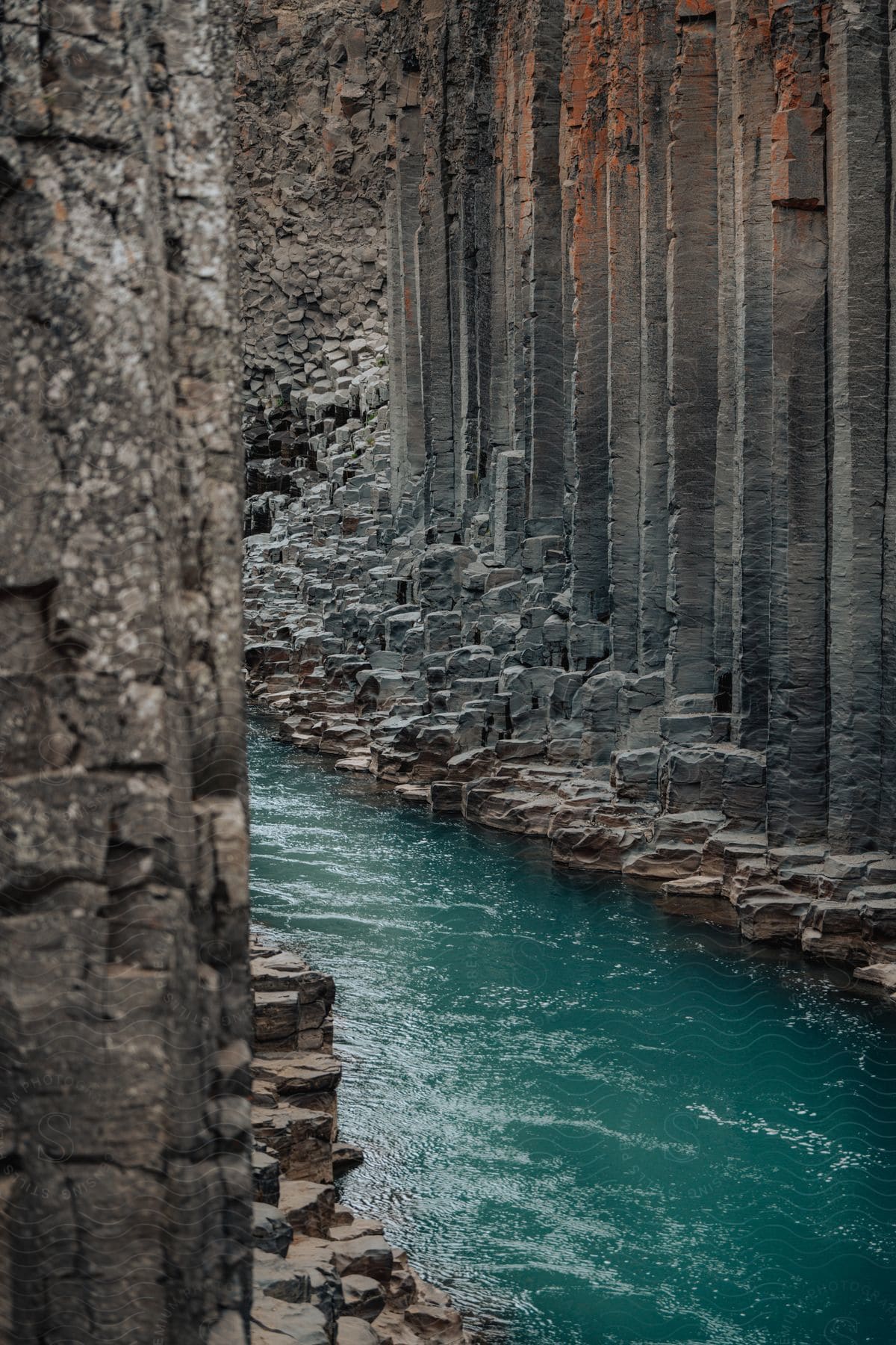 The Jökla River carves a turquoise path through the towering basalt columns of Stuðlagil Canyon.