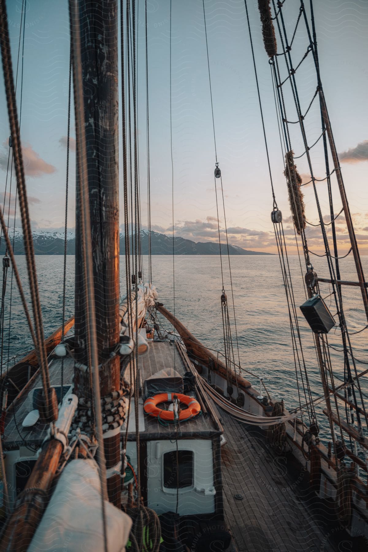 A sailboat headed to a mountainous coast.