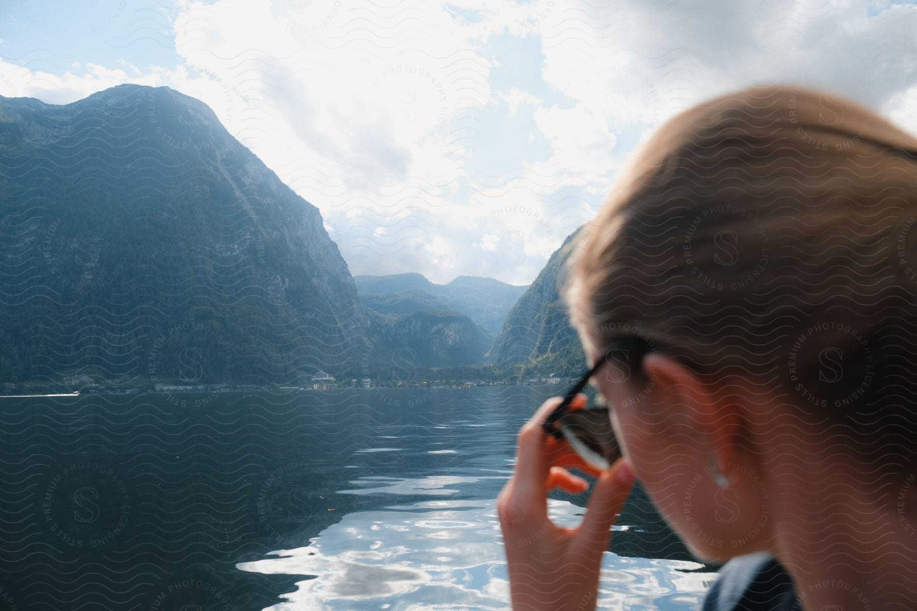 A woman looking over her sunglasses out at a lake