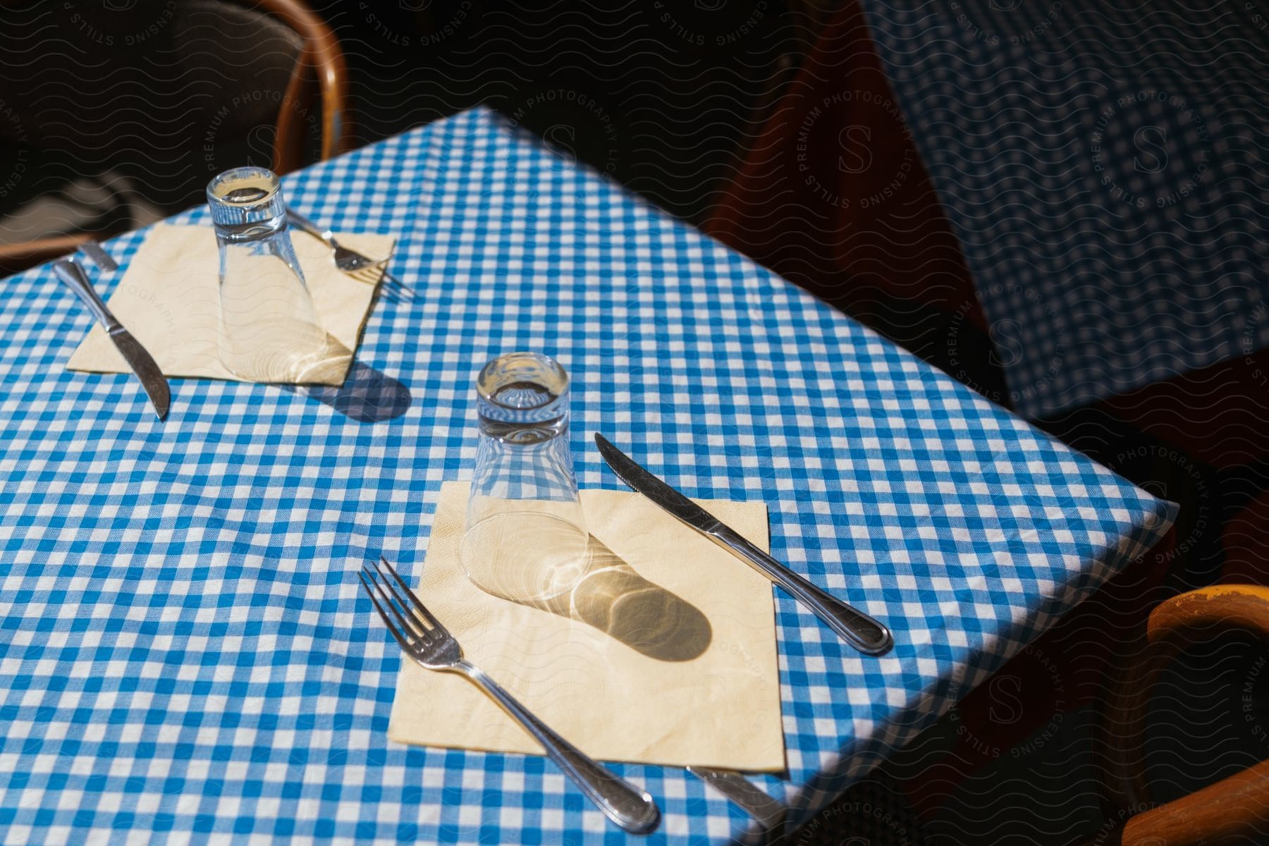 A square table set for two with a cup, fork, knife, and napkin.