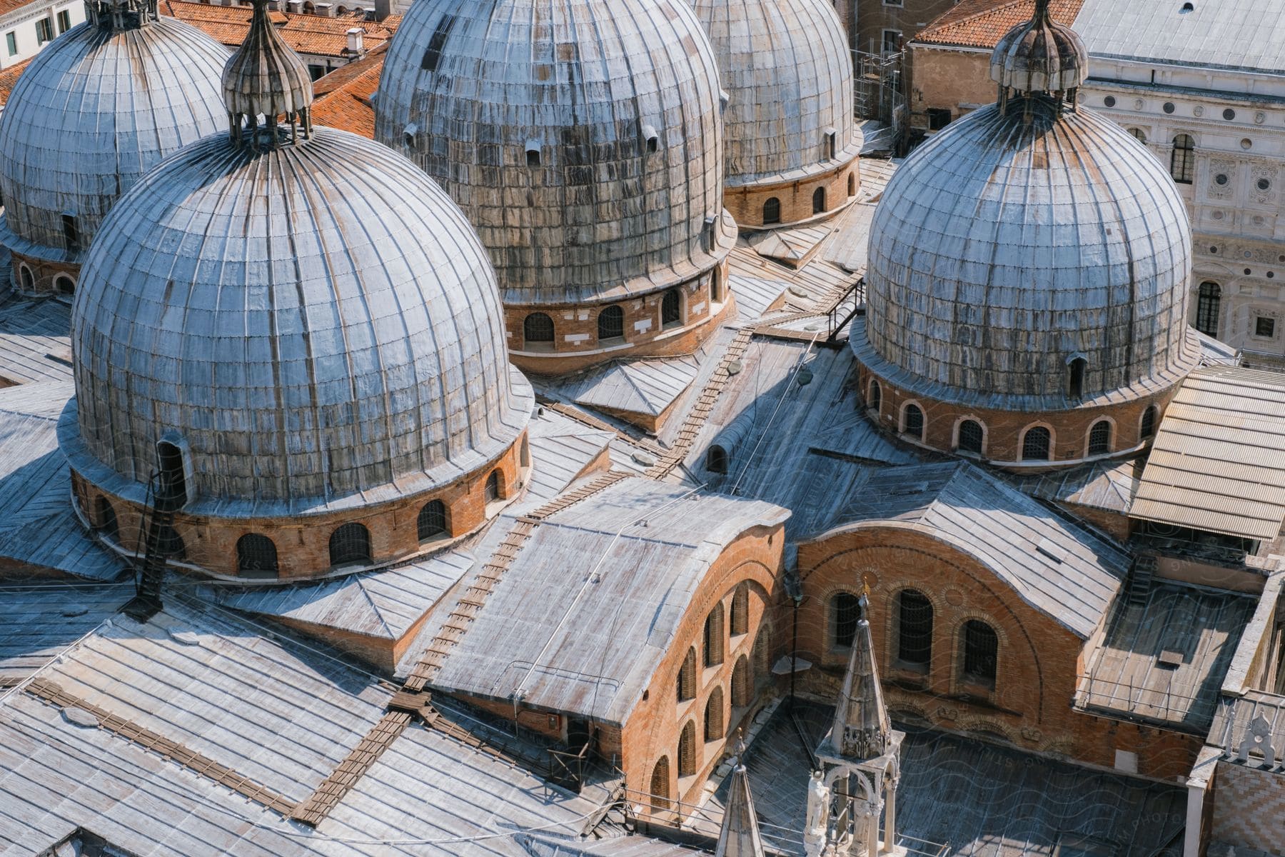 Aerial view of the five domes of Saint Mark's Basilica, with an entrance staircase leading up to one of the domes.
