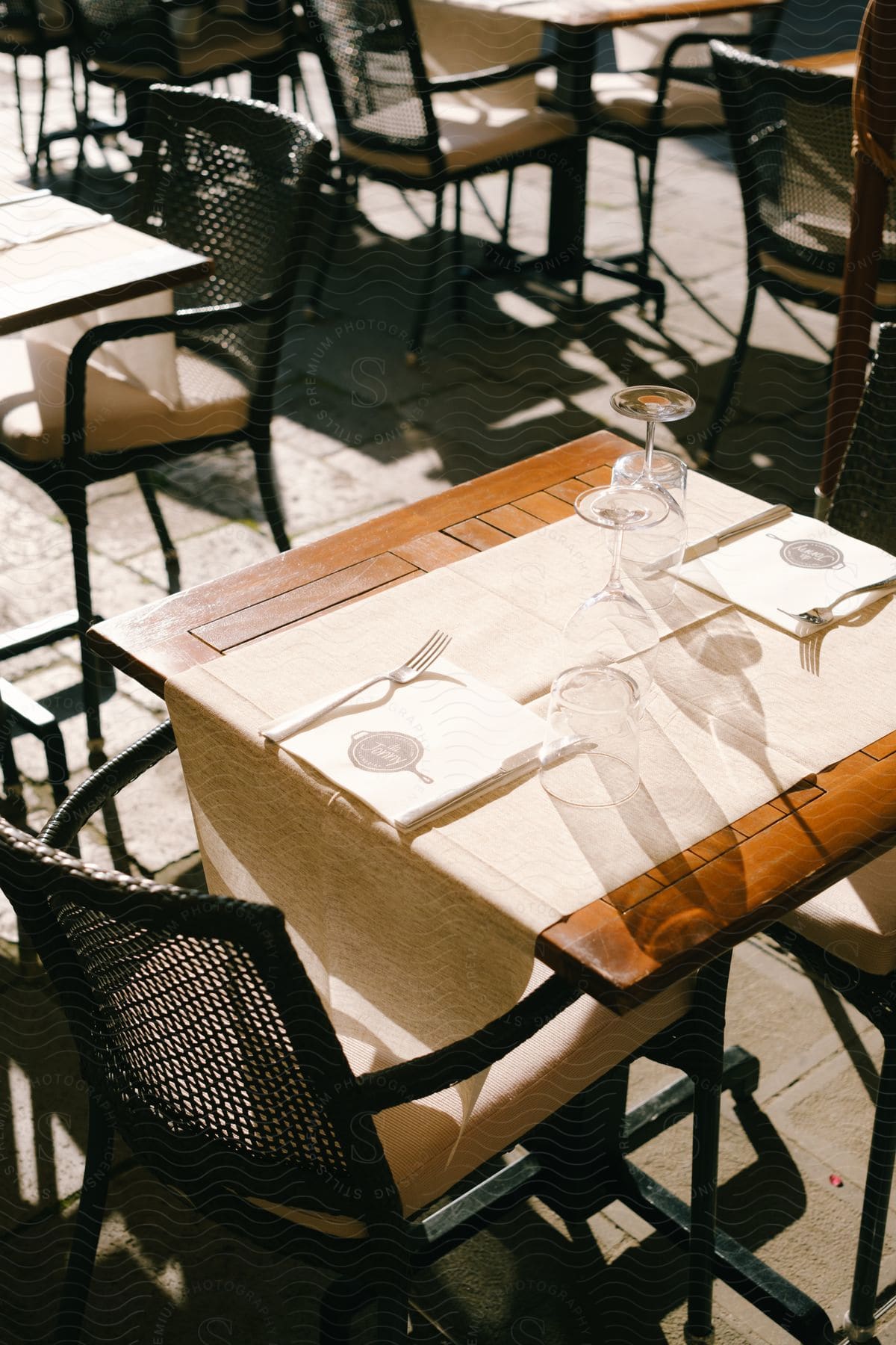 Glasses sit upside down on wooden table in restaurant.