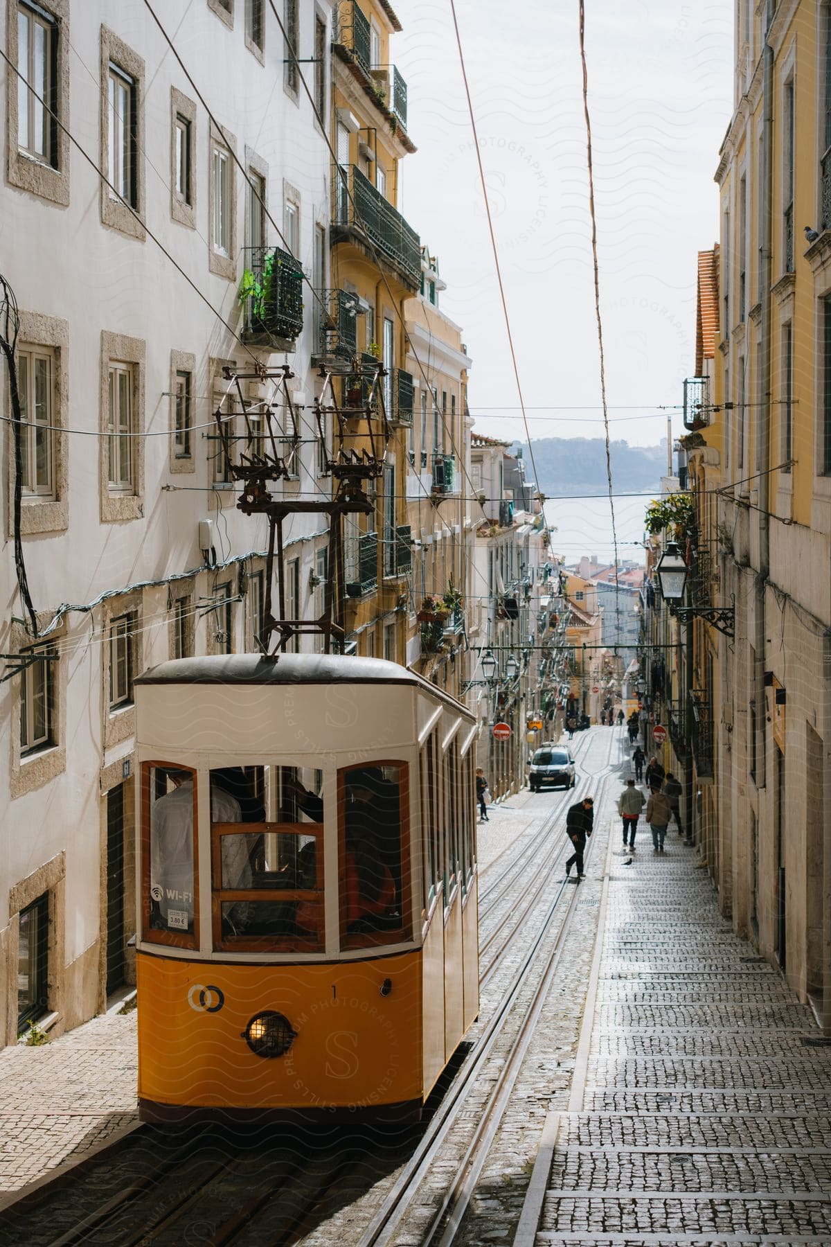 A Packed Trolley Travels Down A City Street