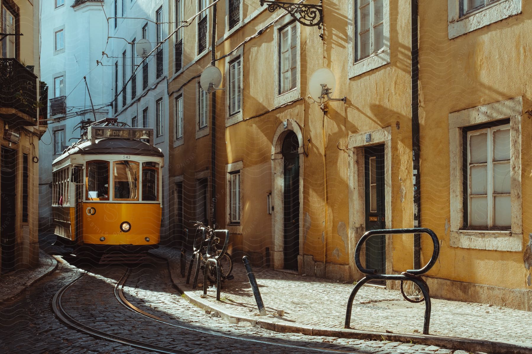 A cable car going through a narrow old Lisbon street.