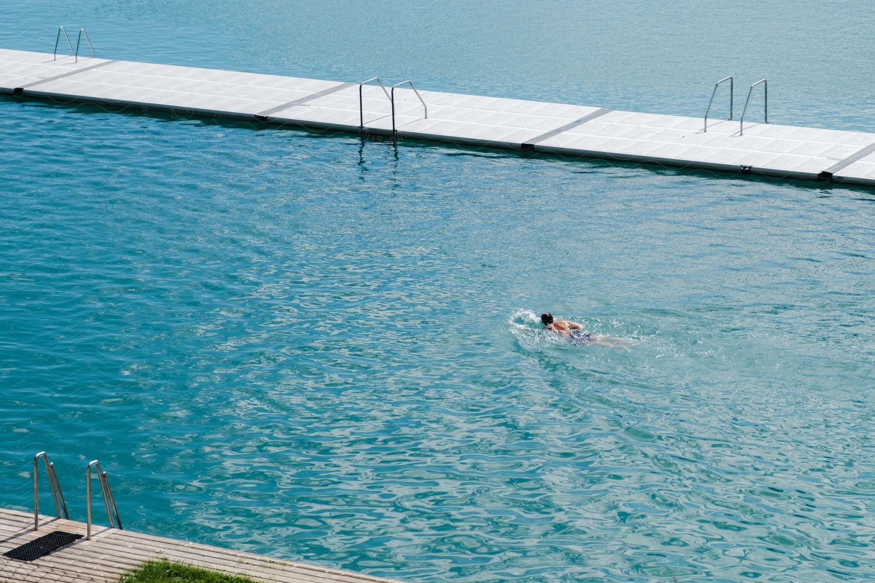 Person wearing swim cap swimming in pool.