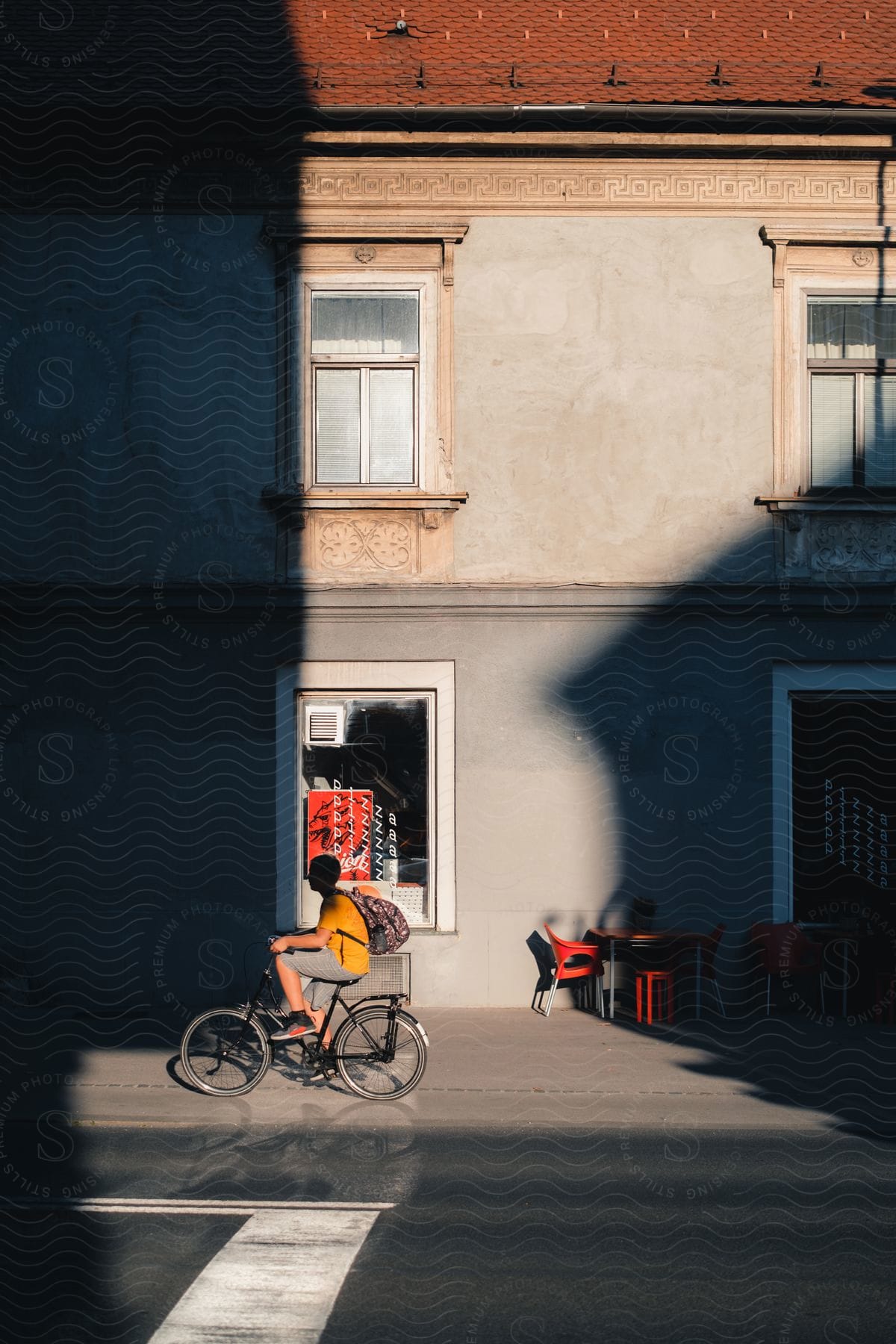 Man riding a bicycle by the sidewalk in daytime