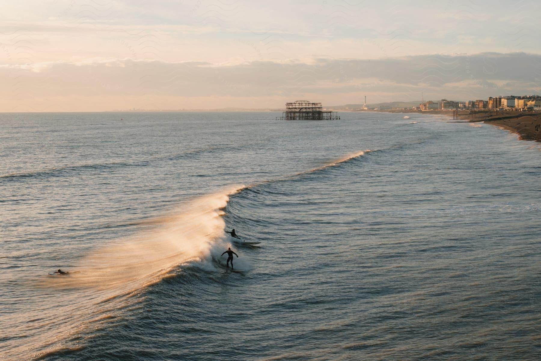 Two people surfing on a large wave outdoors