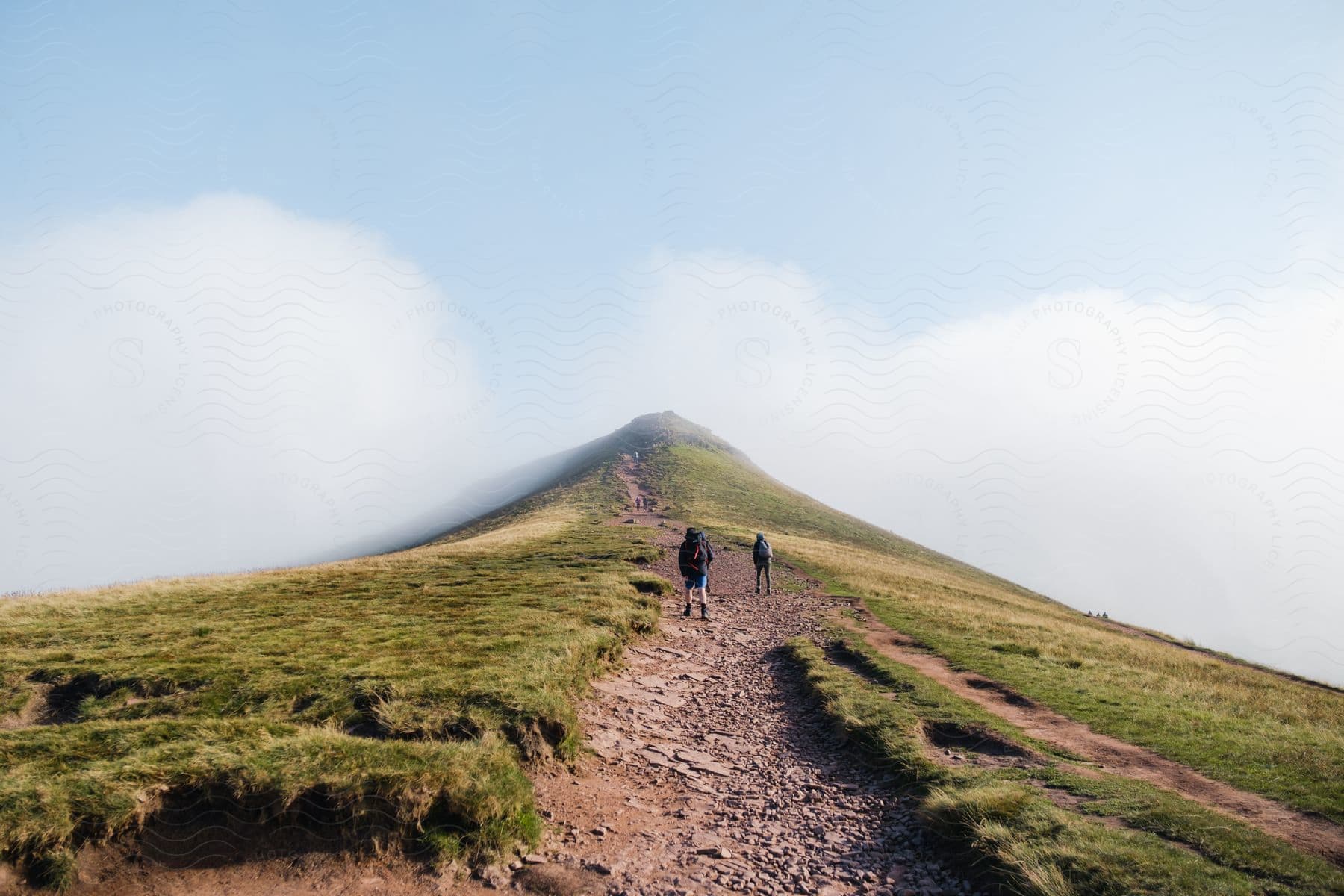 Some people hiking up a mountain outdoors