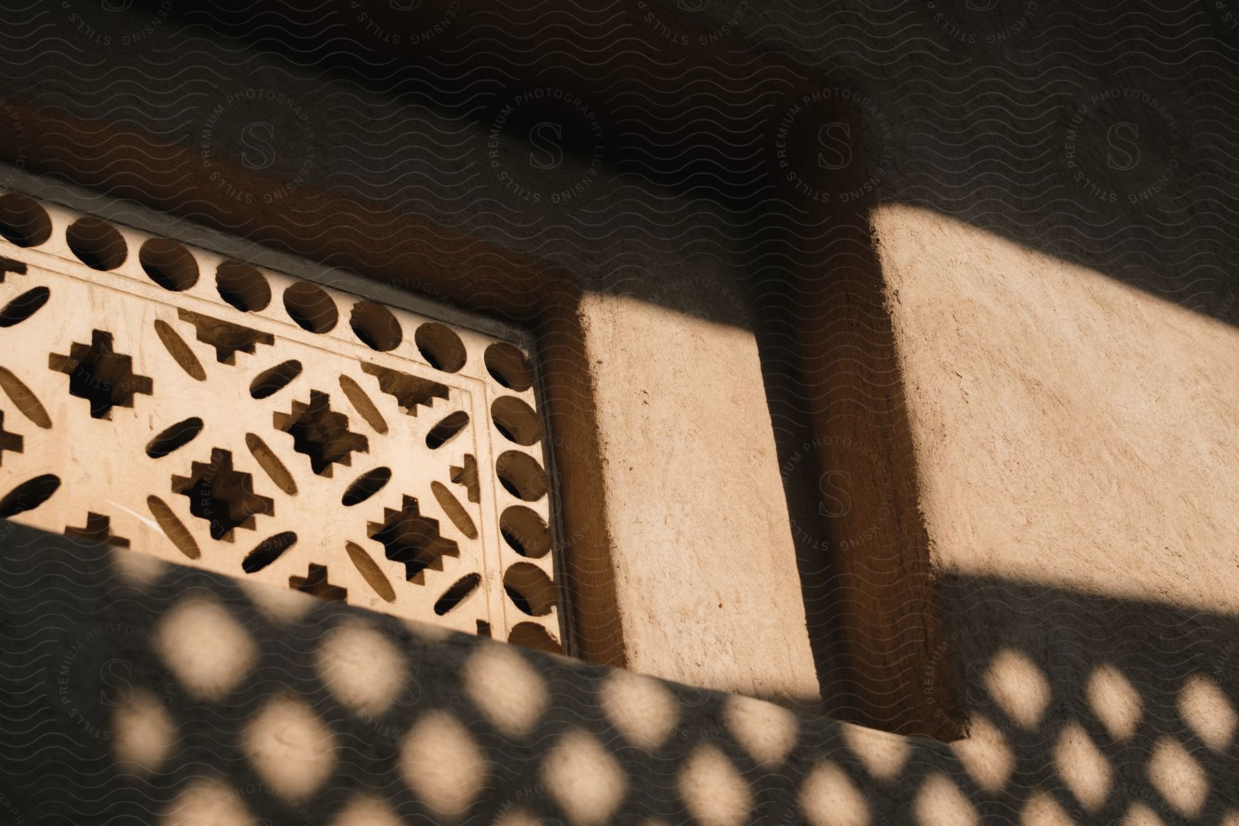 a lattice fence creates a pattern against the side of a building