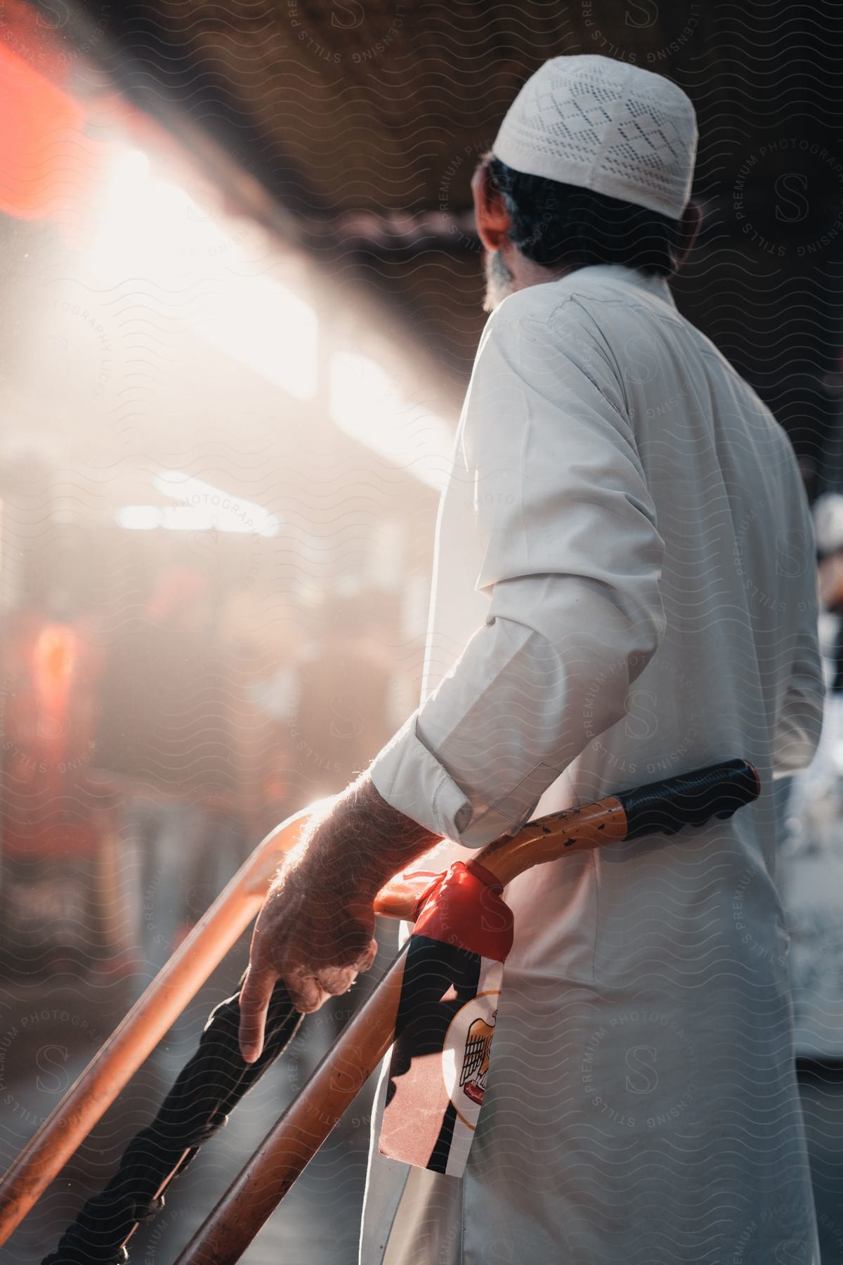 Man wearing white hat and white coat stands beside a push utility.