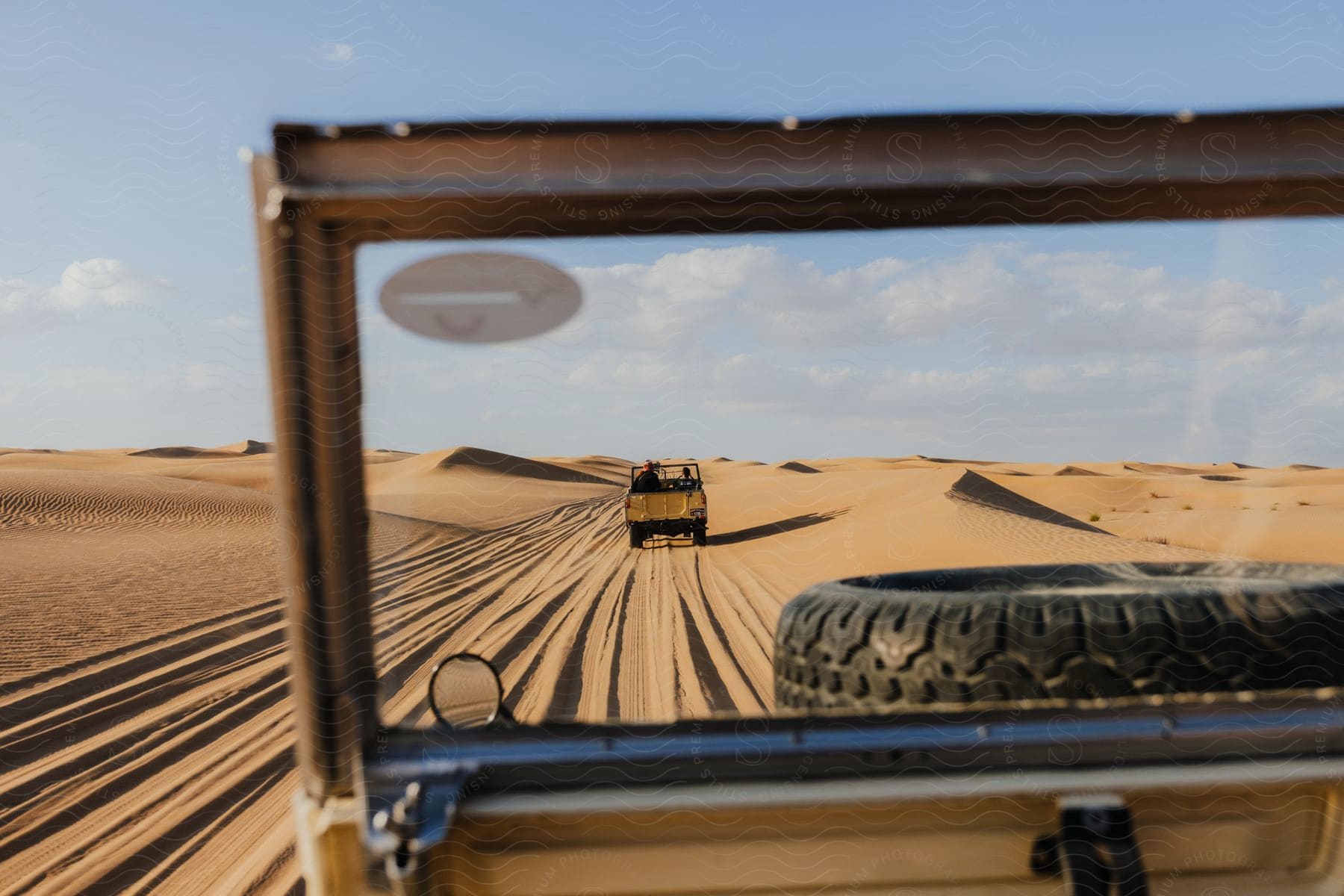 Two trucks driving through the sandy desert and dunes