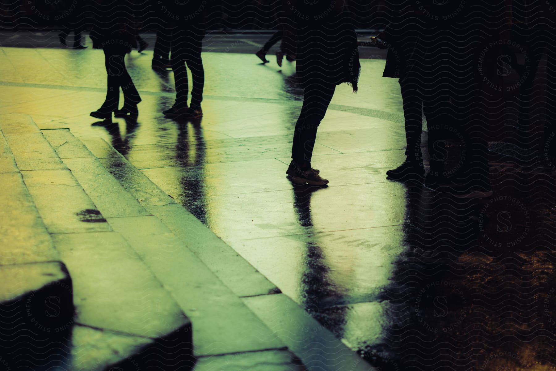 People walking on a dark sidewalk.