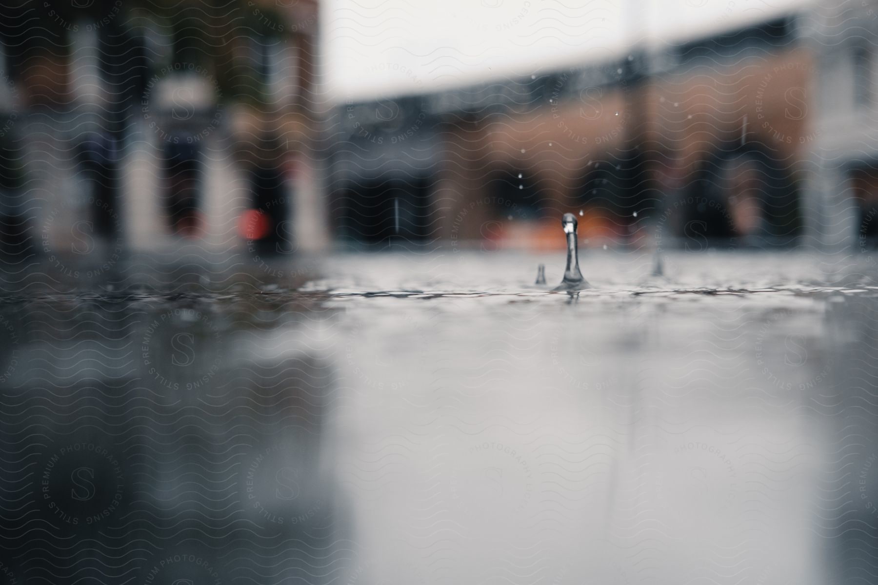 Rain droplets splashing onto a city street.