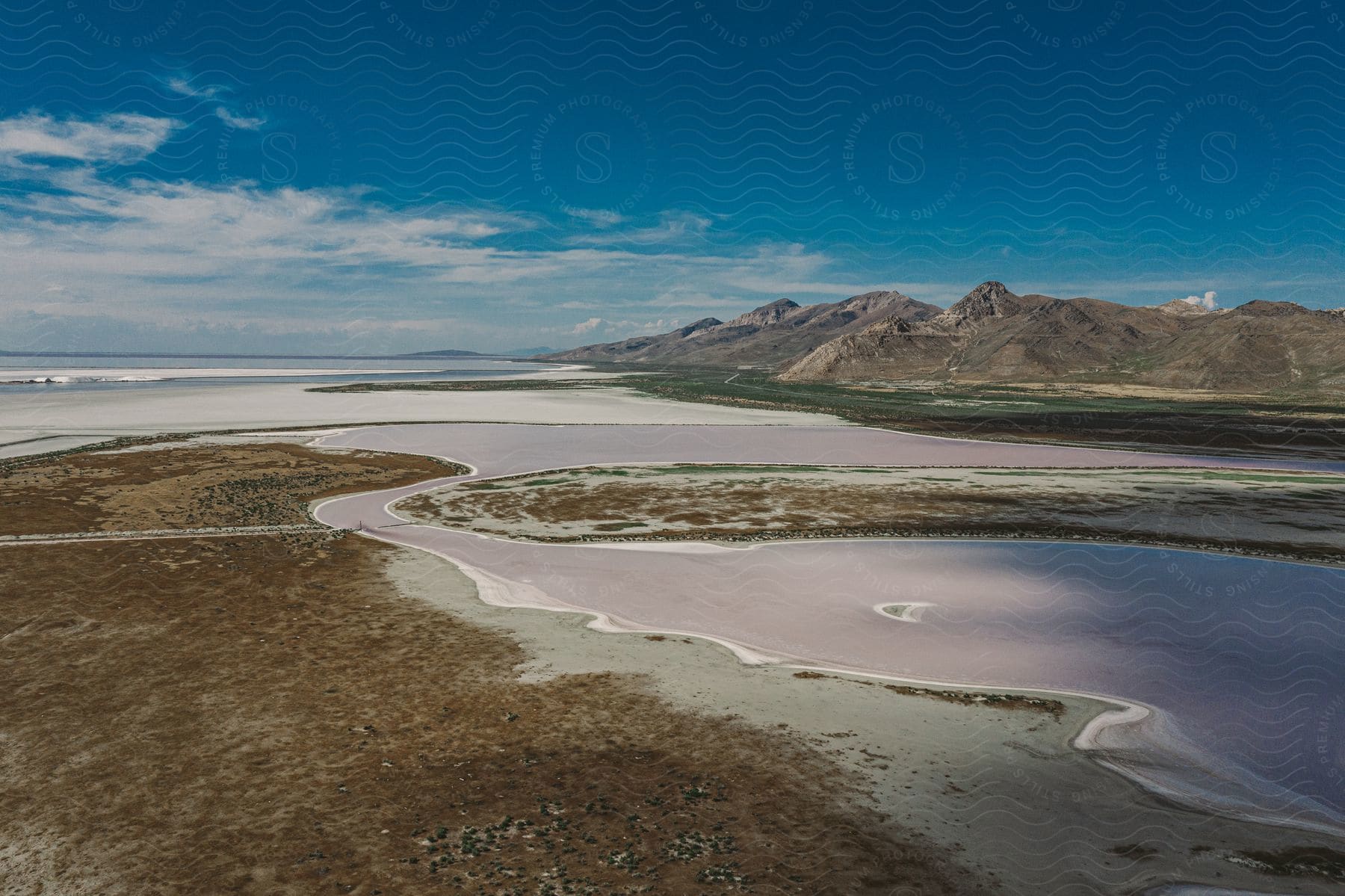 a wide open area with a body of water and mountains in the background