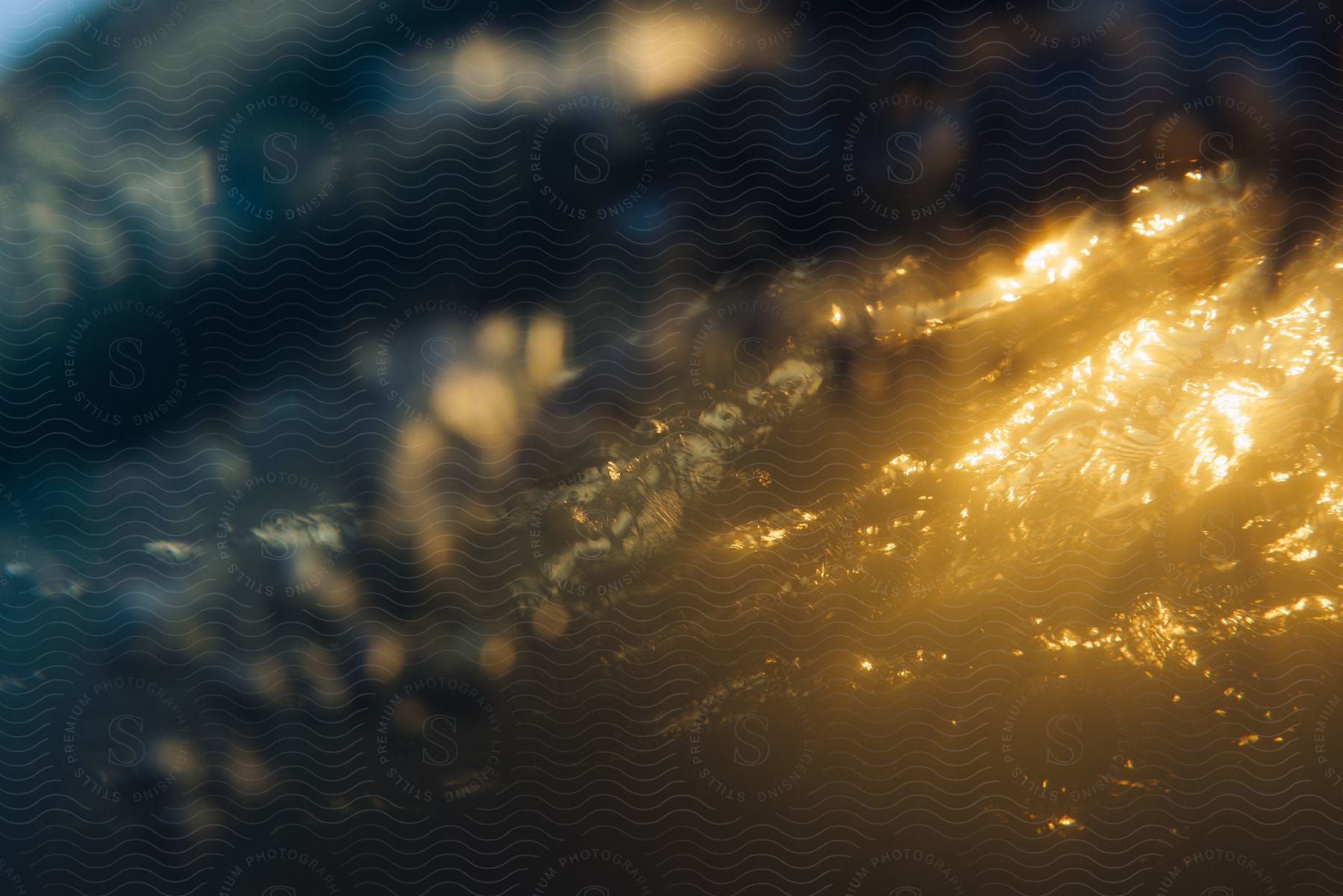 Golden sunlight reflects on splashing water along the coast.