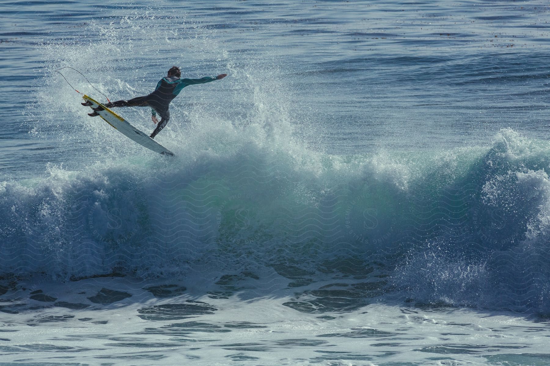 A man wearing a swimsuit fearlessly surfs on the sea, riding a powerful wave that propels him into the air on top of his surfboard