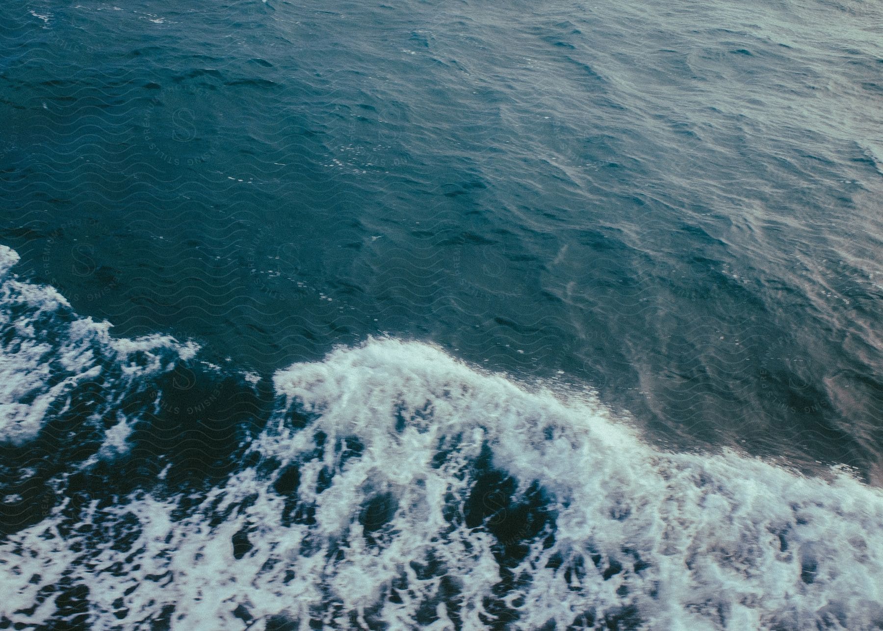 Ocean waves crashing and rolling across the ocean surface.