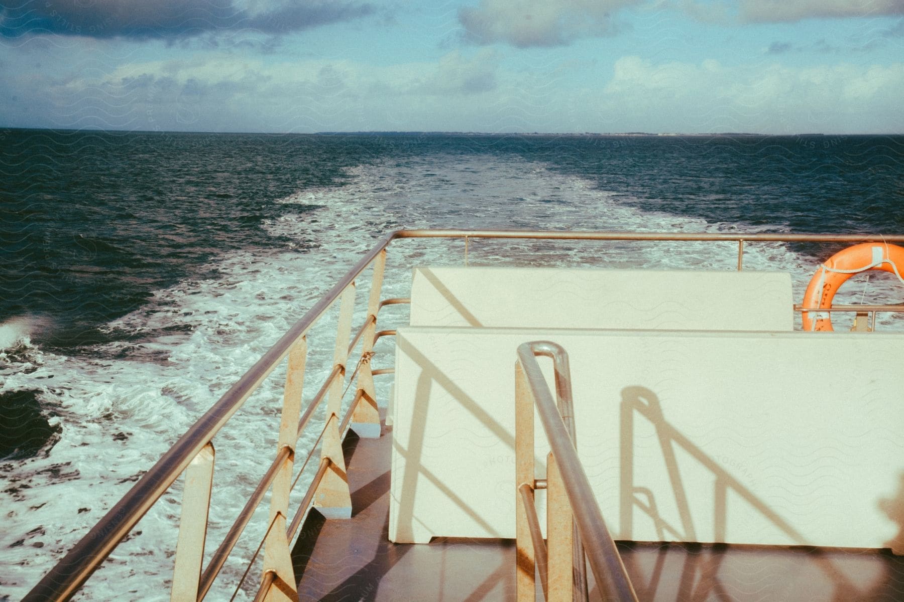 A boat is traveling and its engine splashes the ocean water.