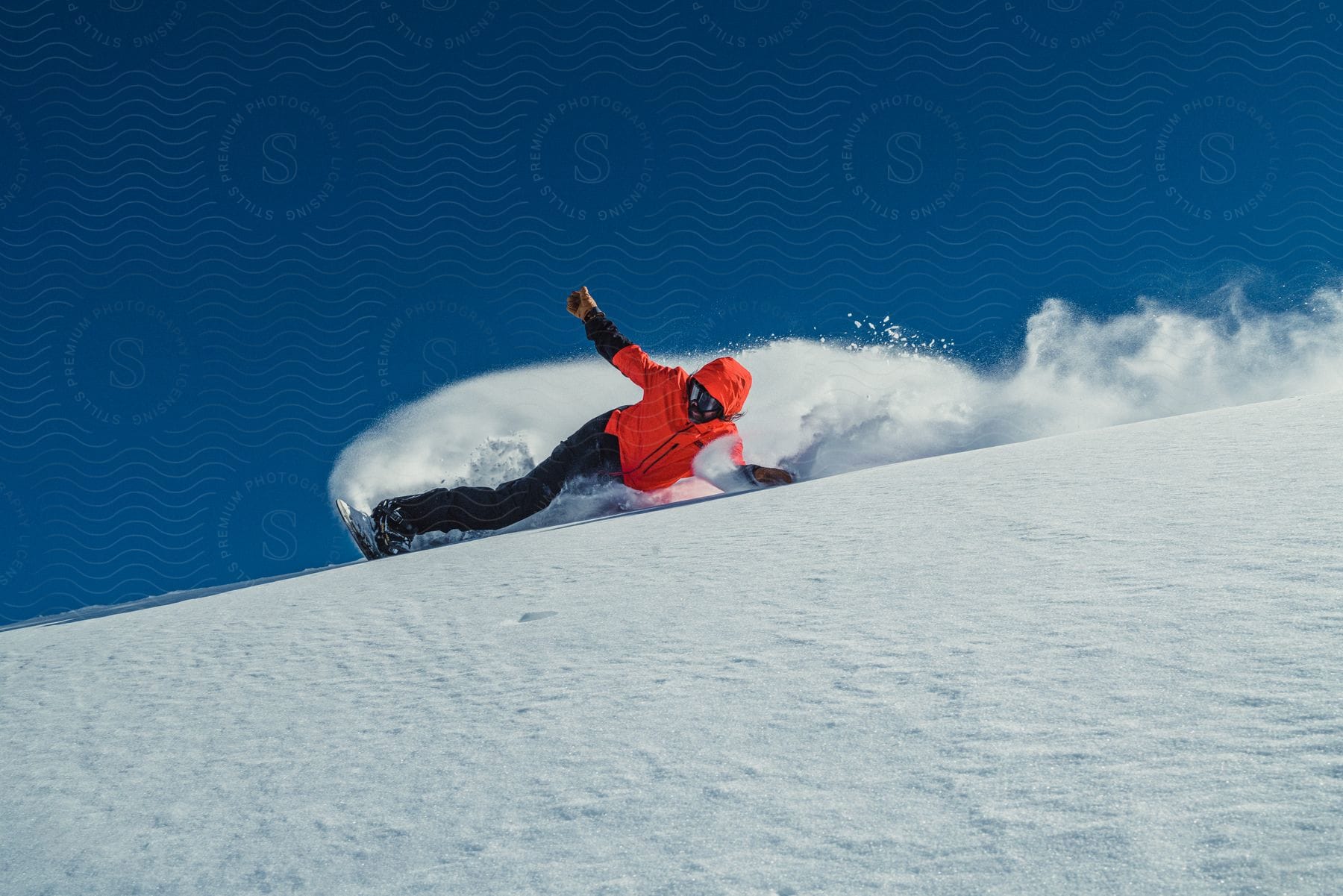 A person clad in winter gear, snowboarding through the snow, skillfully gliding with hands scraping the snow.