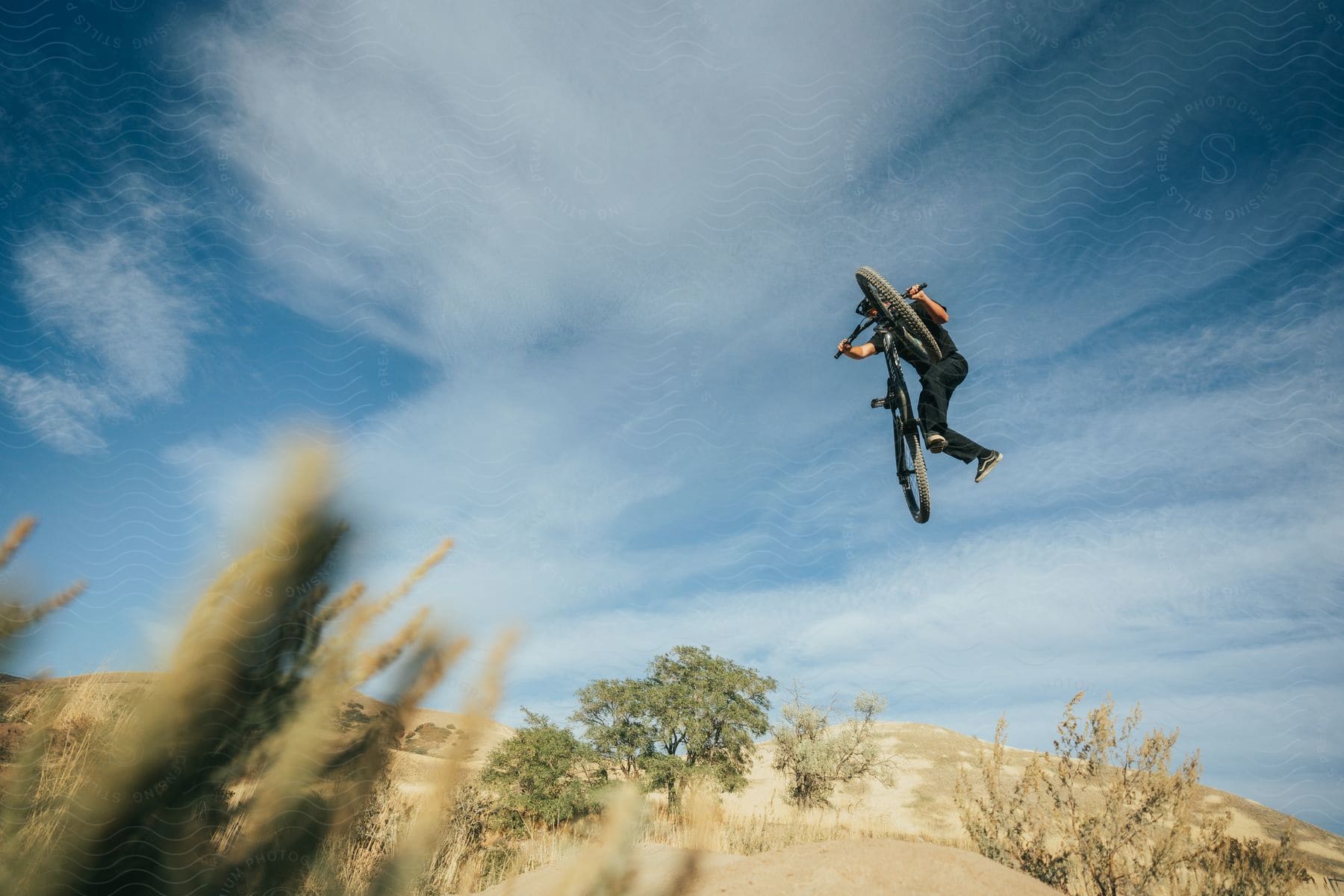 a man is performing stunts on a bike during midday