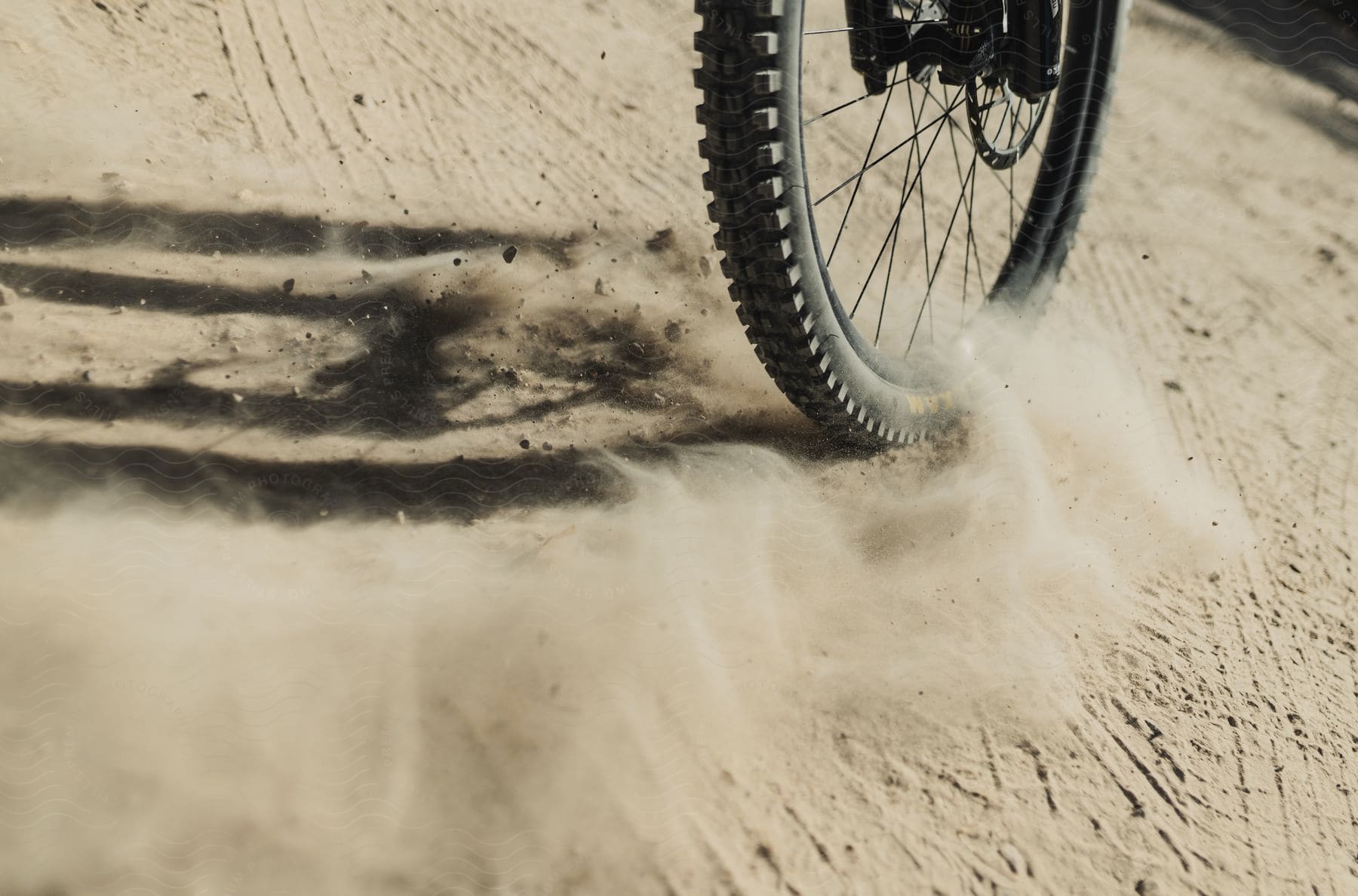 A bicycle drifting out in some dirt