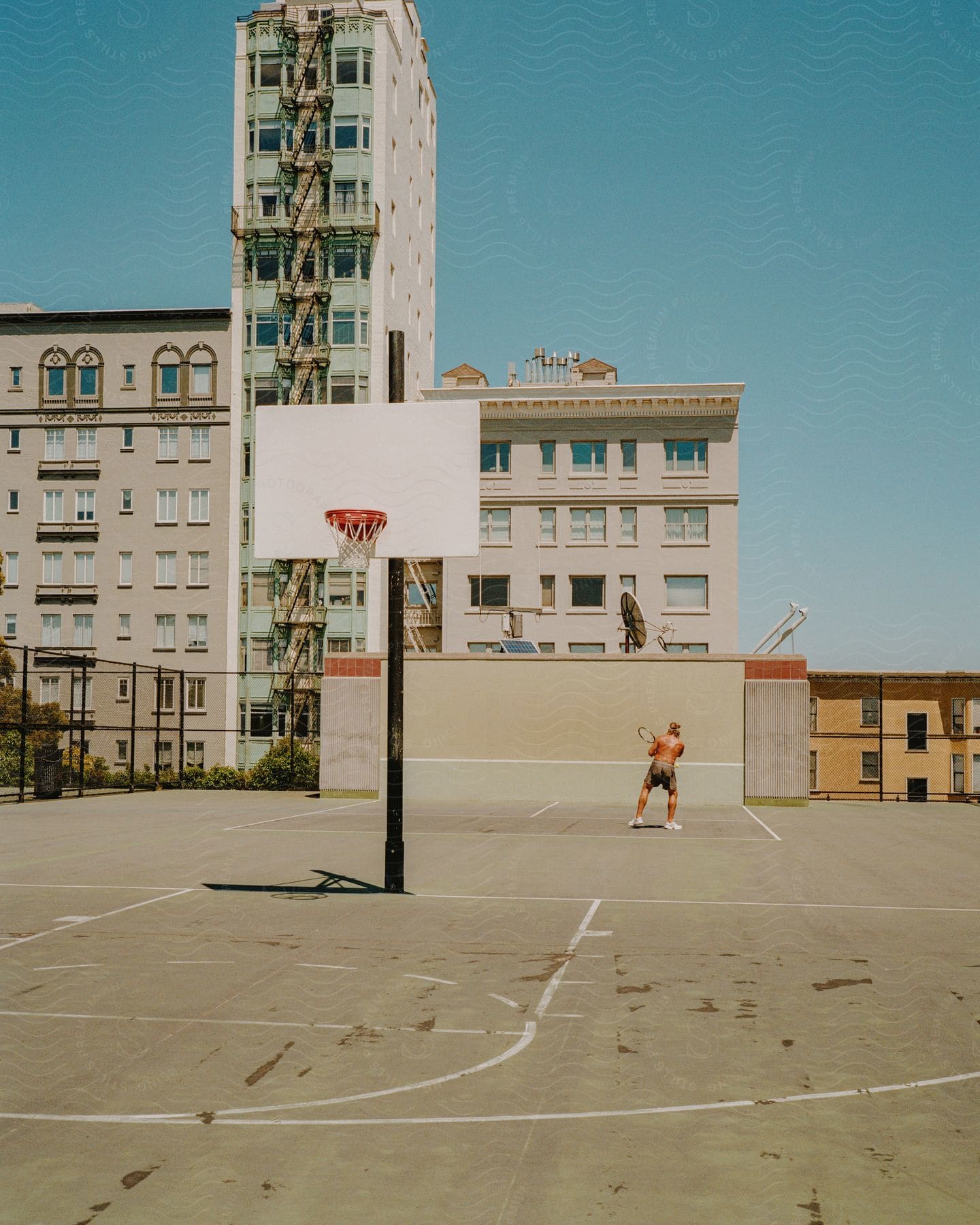 A man hitting a tennis ball against a wall outdoors