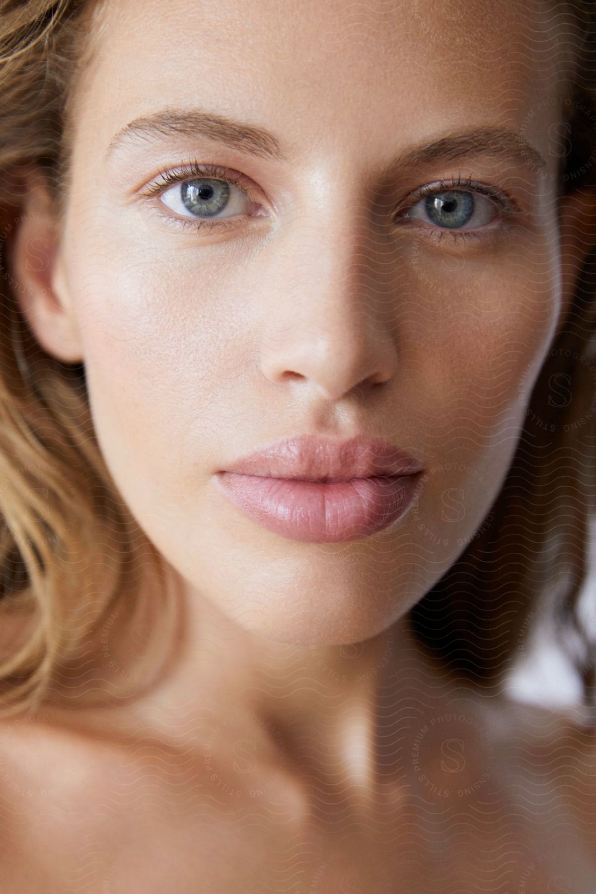 A blue eyed woman with beautiful lips and natural looking makeup