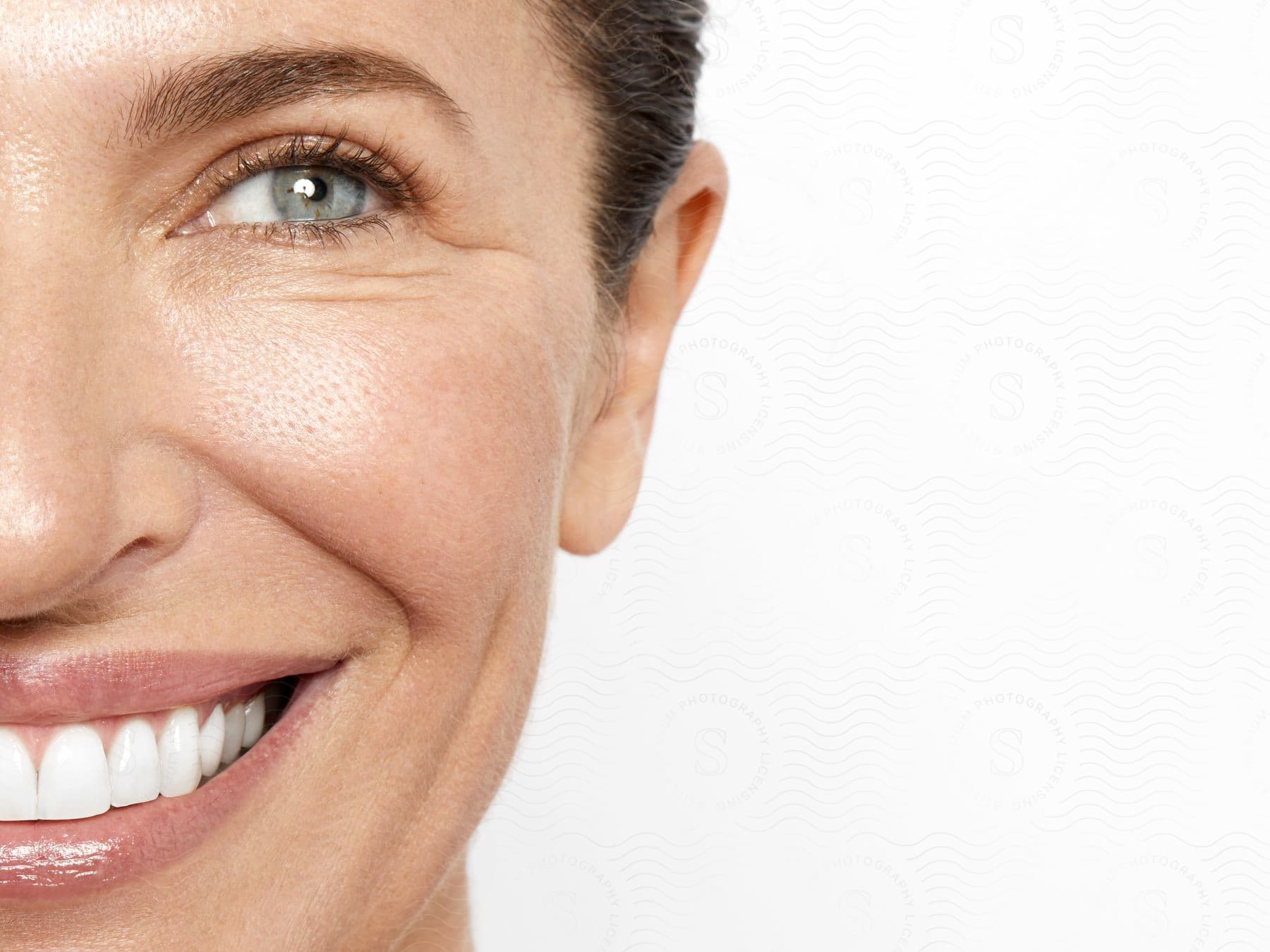 Woman grins creating crinkles under her eyes.