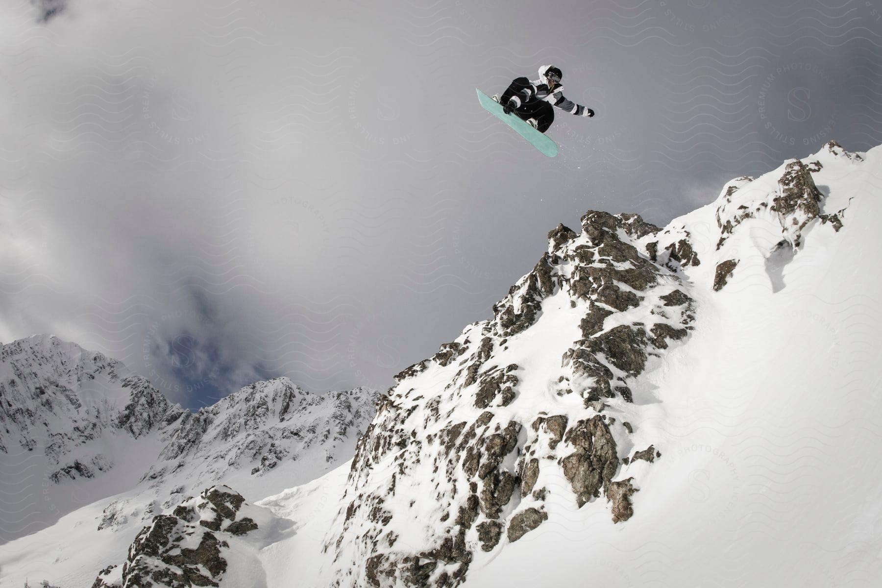 Jumping on a snowboard in the mountains.