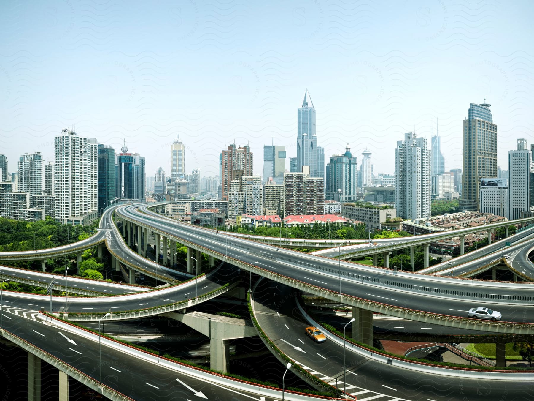 The Nine Dragons Intersection is a bustling highway intersection in Shanghai, with multiple lanes of traffic, a city skyline in the background, and blue skies overhead.