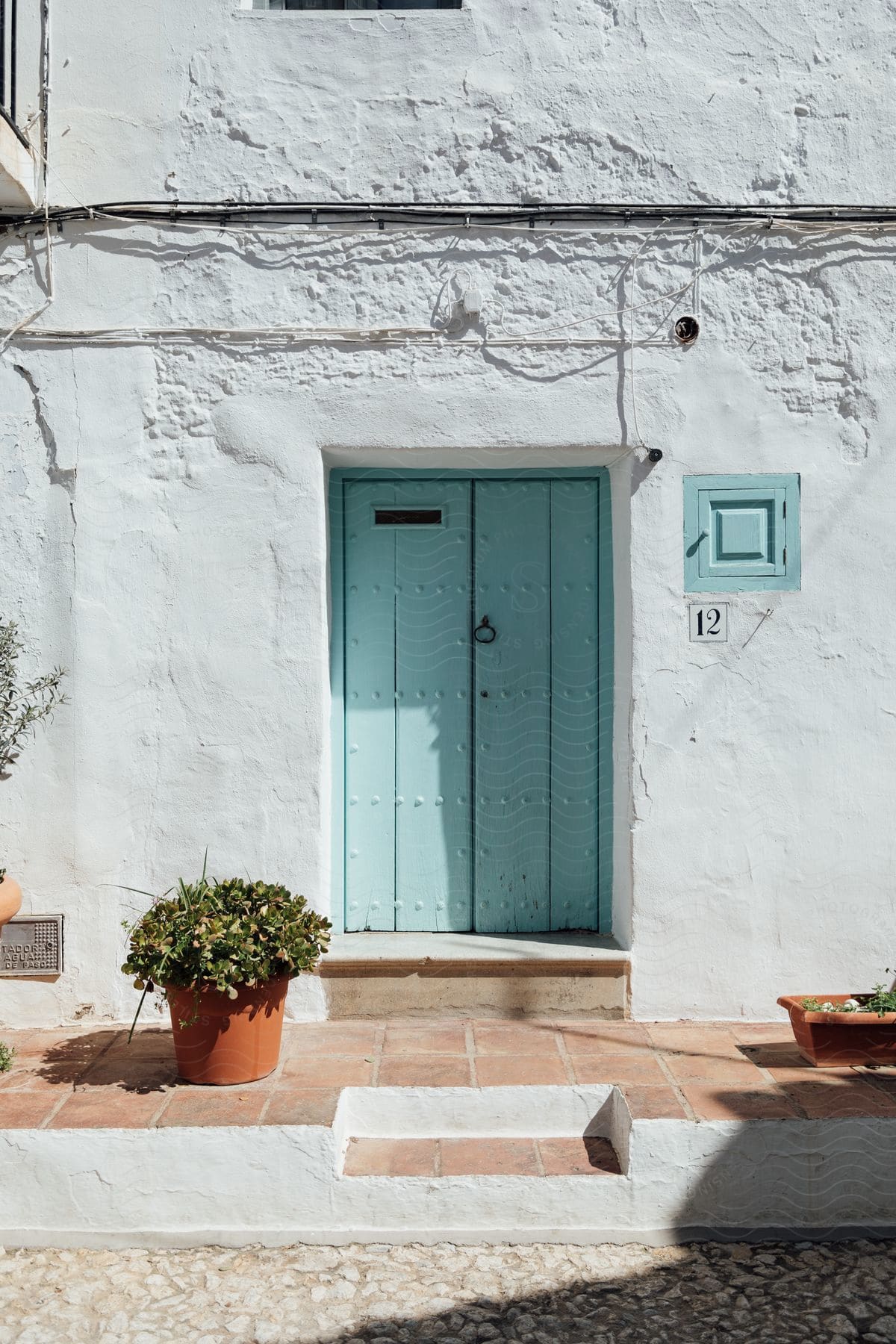 A blue door in a whitewashed wall.