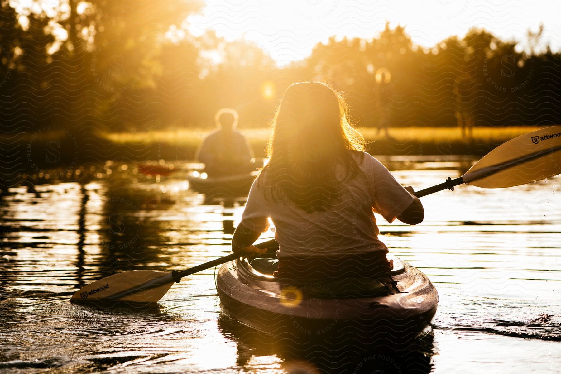 Two people canoeing on the lake in the late afternoon.