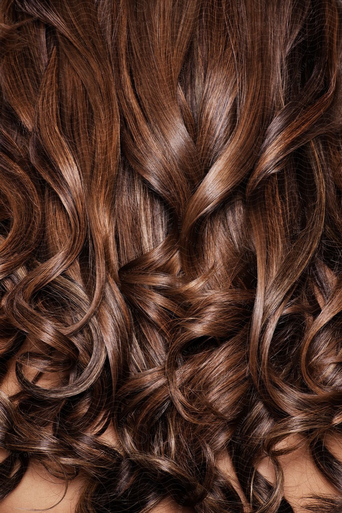 Long hydrated and luminous brown hair with curls.