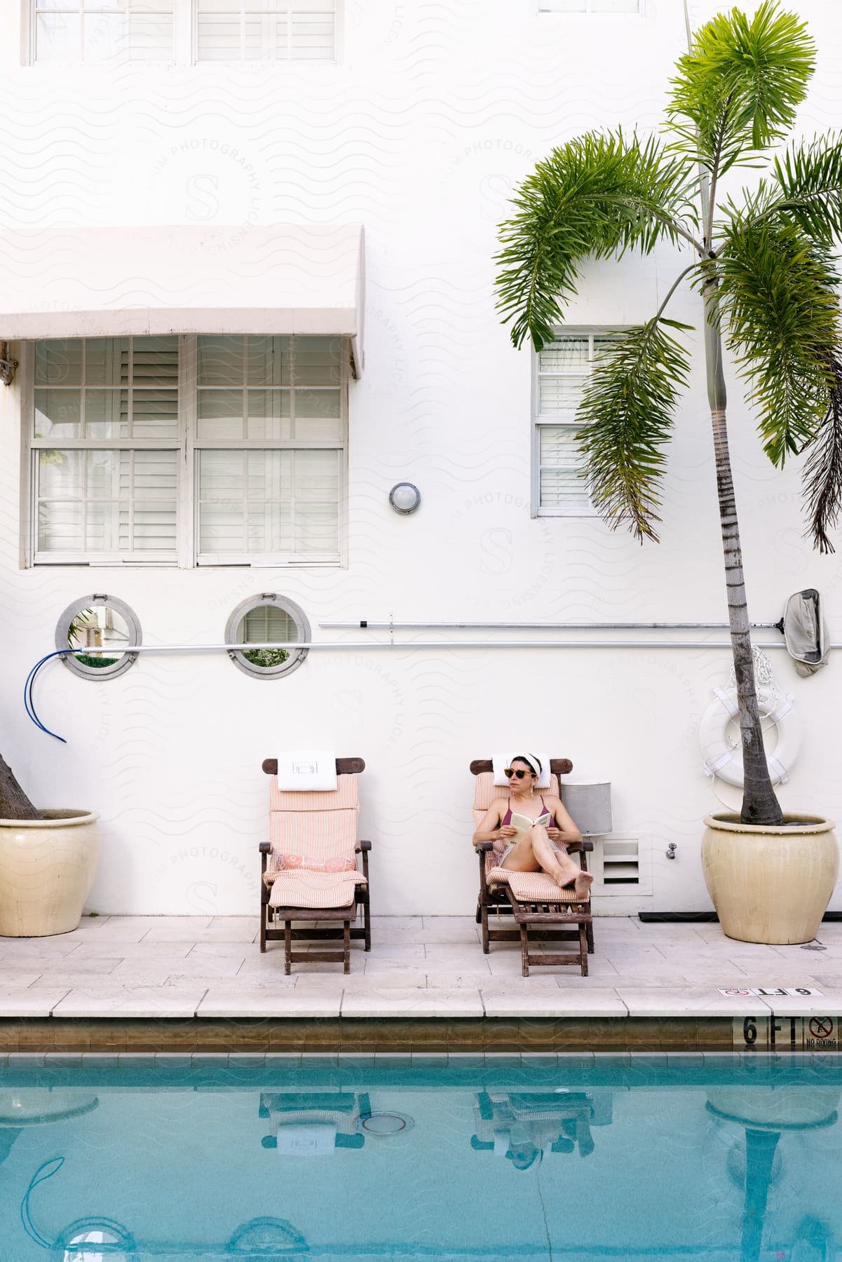 a woman lounges poolside at a hotel