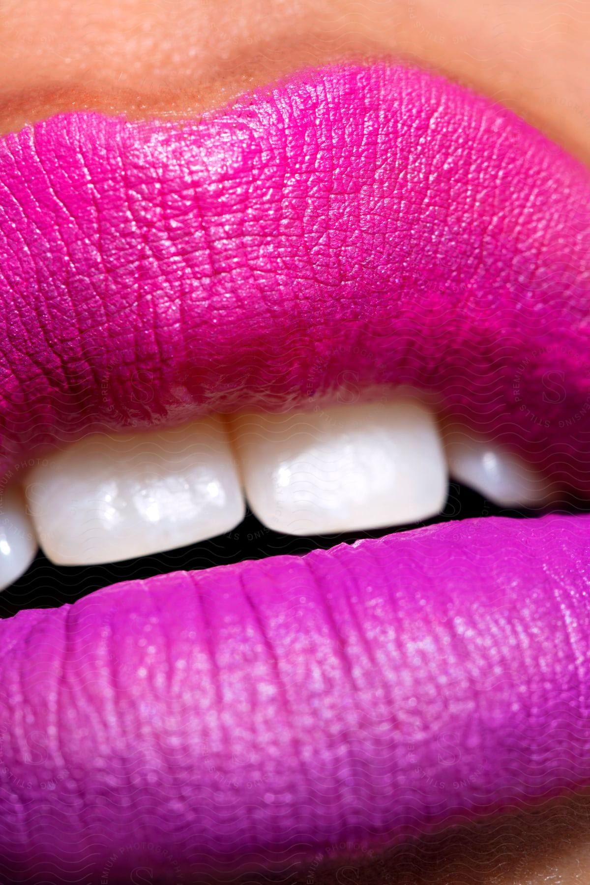 An open mouth with pink painted lips.