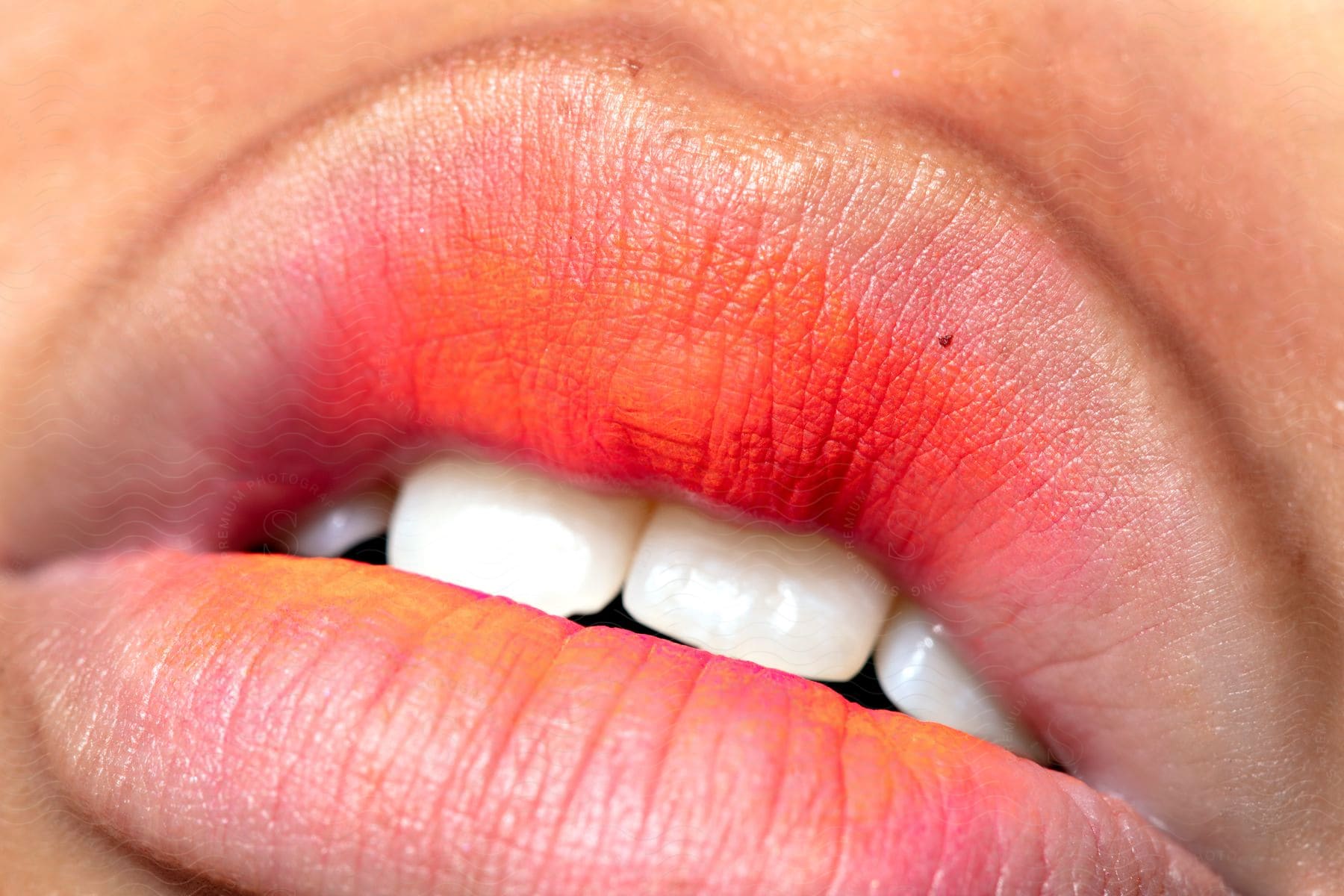 Extreme close-up of a mouth with a little lipstick.