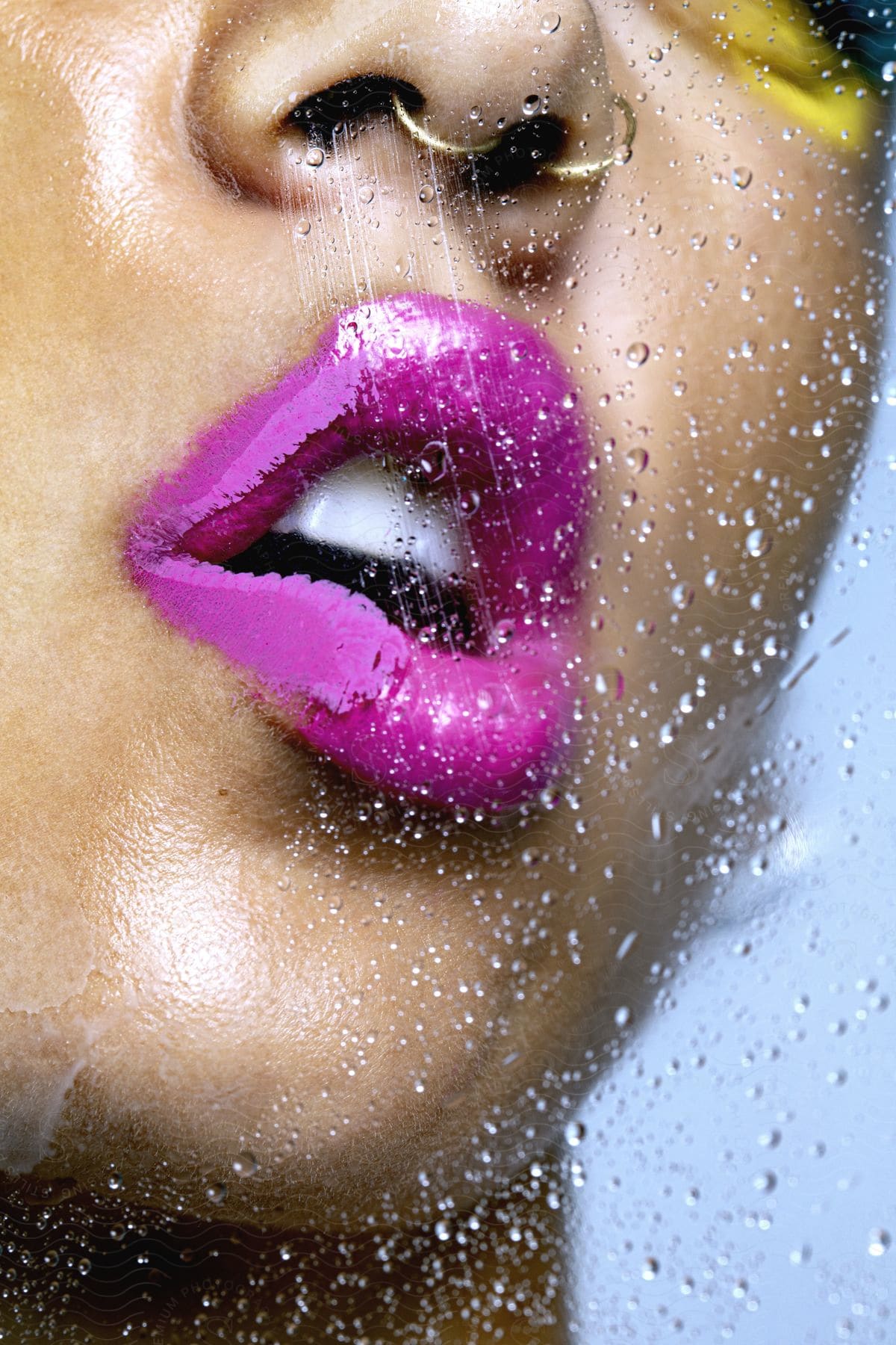 Stock photo of a woman is wearing bright pink lipstick and a gold nose ring.