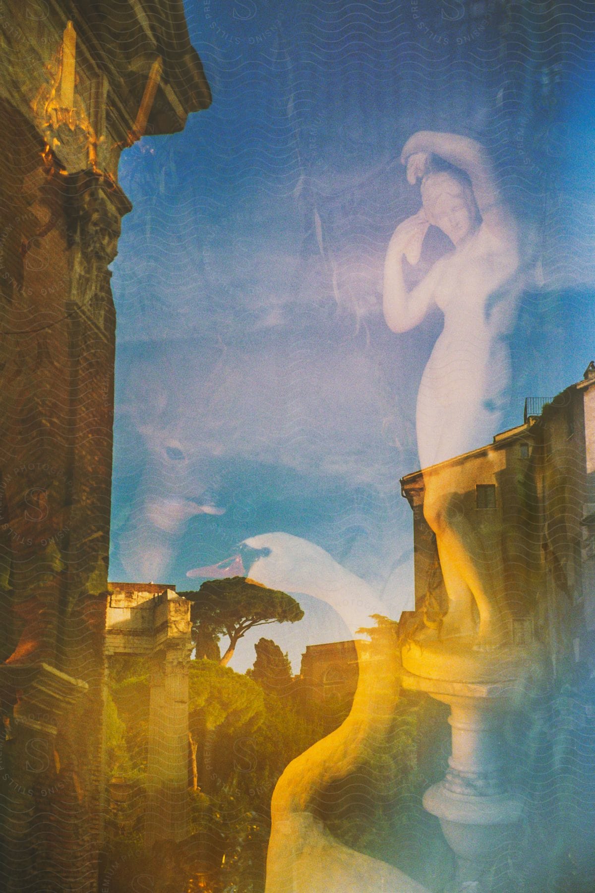 A classical style city street, seen through a glass reflecting statues of a woman and a swan.