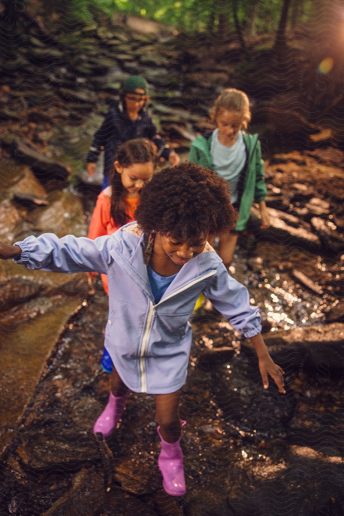 Four young girls stepping over a creek.