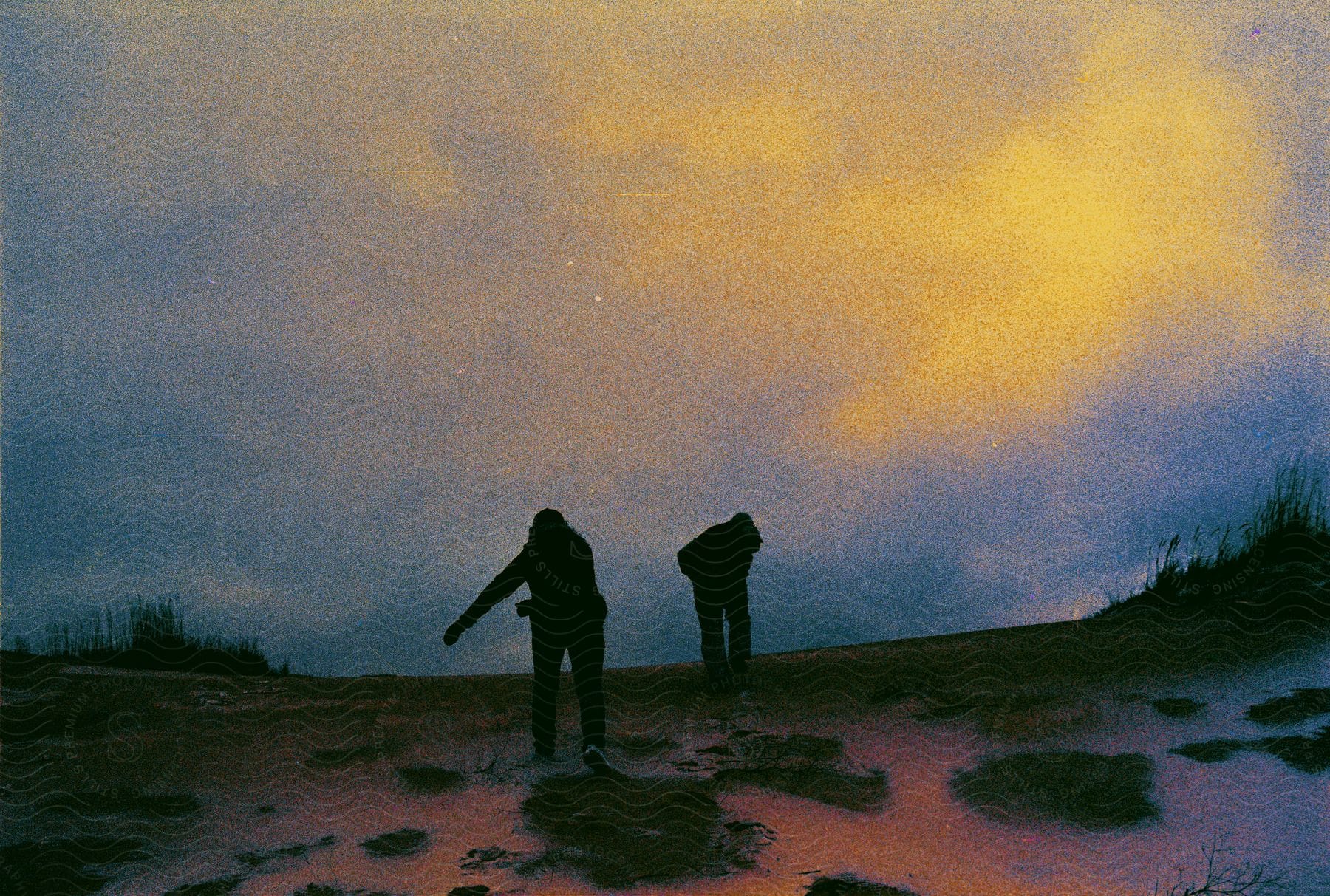 Silhouette of two people walking.