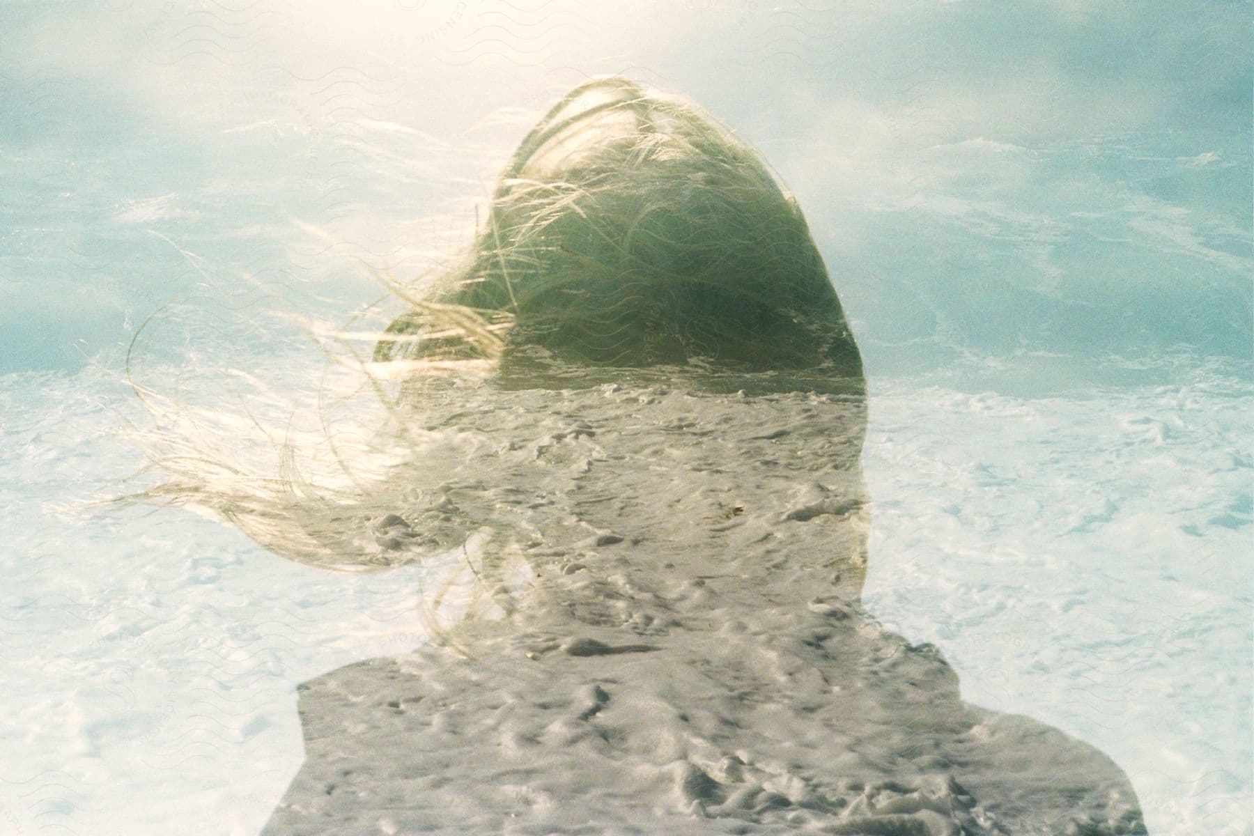 A girl standing in the wind with her hair blowing back.