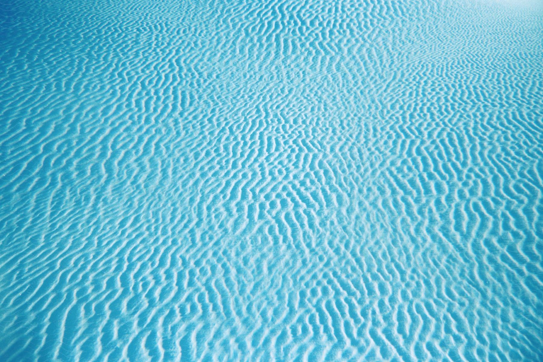 The sand under the blue calm sea