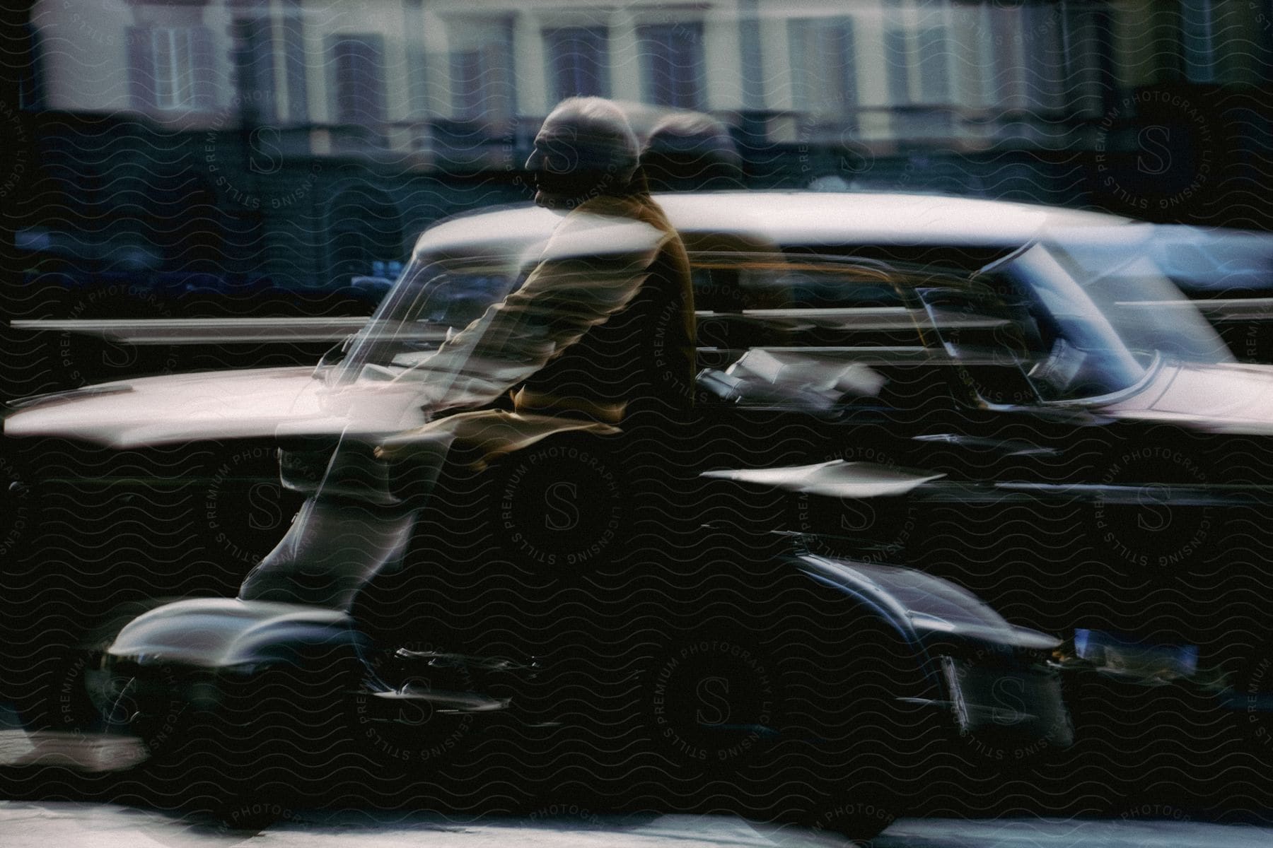 A man on a scooter overtaking a car.